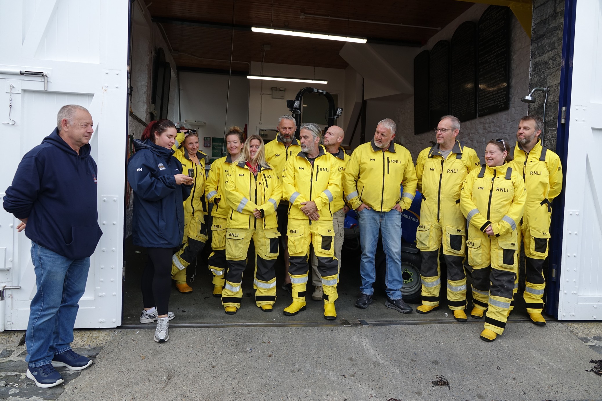 The volunteer crew stood in crew kit in the lifeboat station