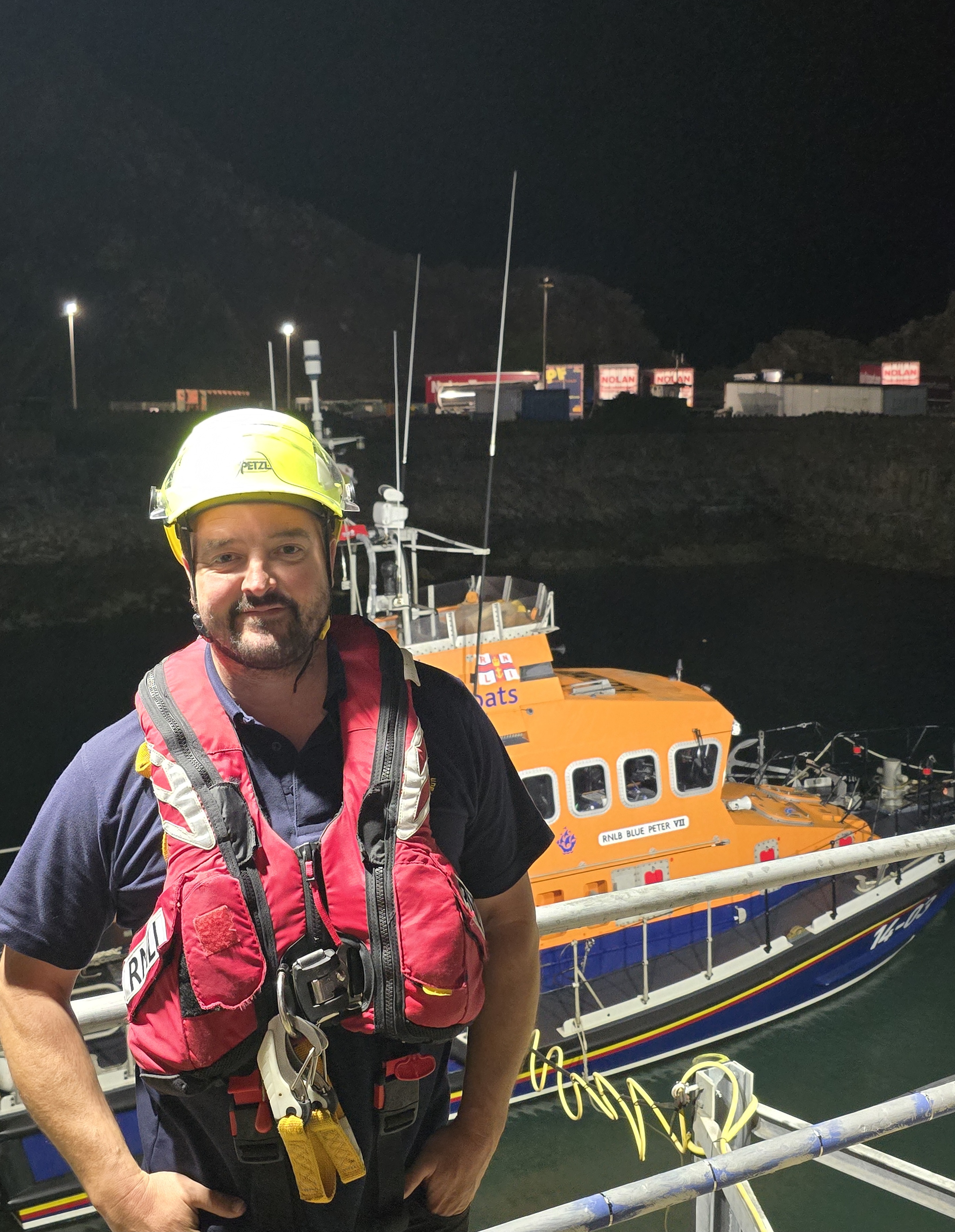 Fishguard RNLI volunteer mechanic Rhys Stilwell in front of the all-weather Trent class lifeboat Blue Peter VII following his first exercise as mechanic.