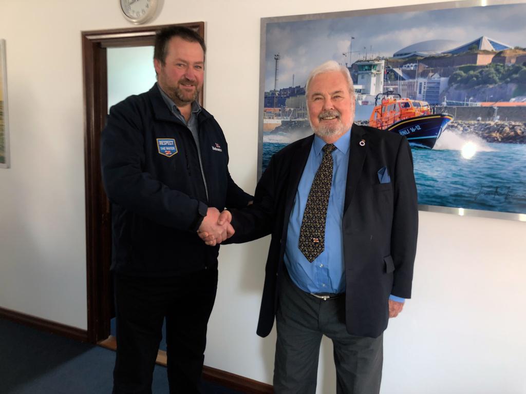 Tom Mansell shakes Philip Barber's hand at the St Helier lifeboat station as he presents his Long Service Award.