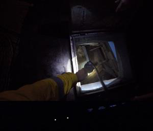 Tower volunteer looking into the deck analysing the water ingress.