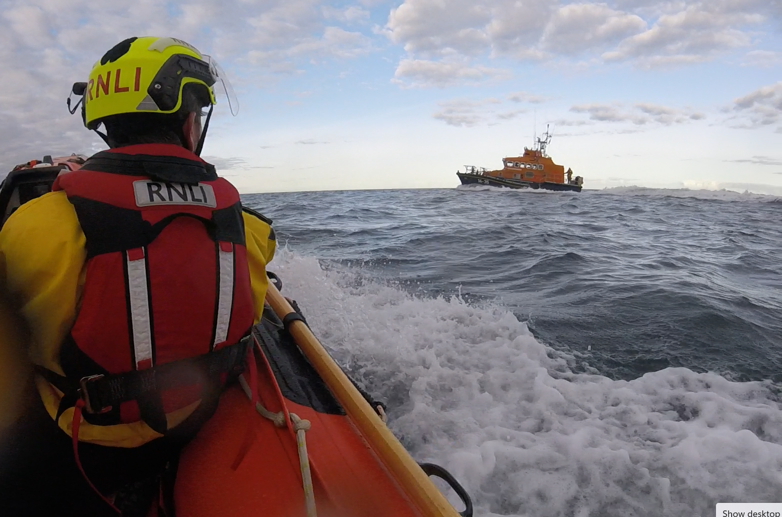 Man in boat watches other lifeboat