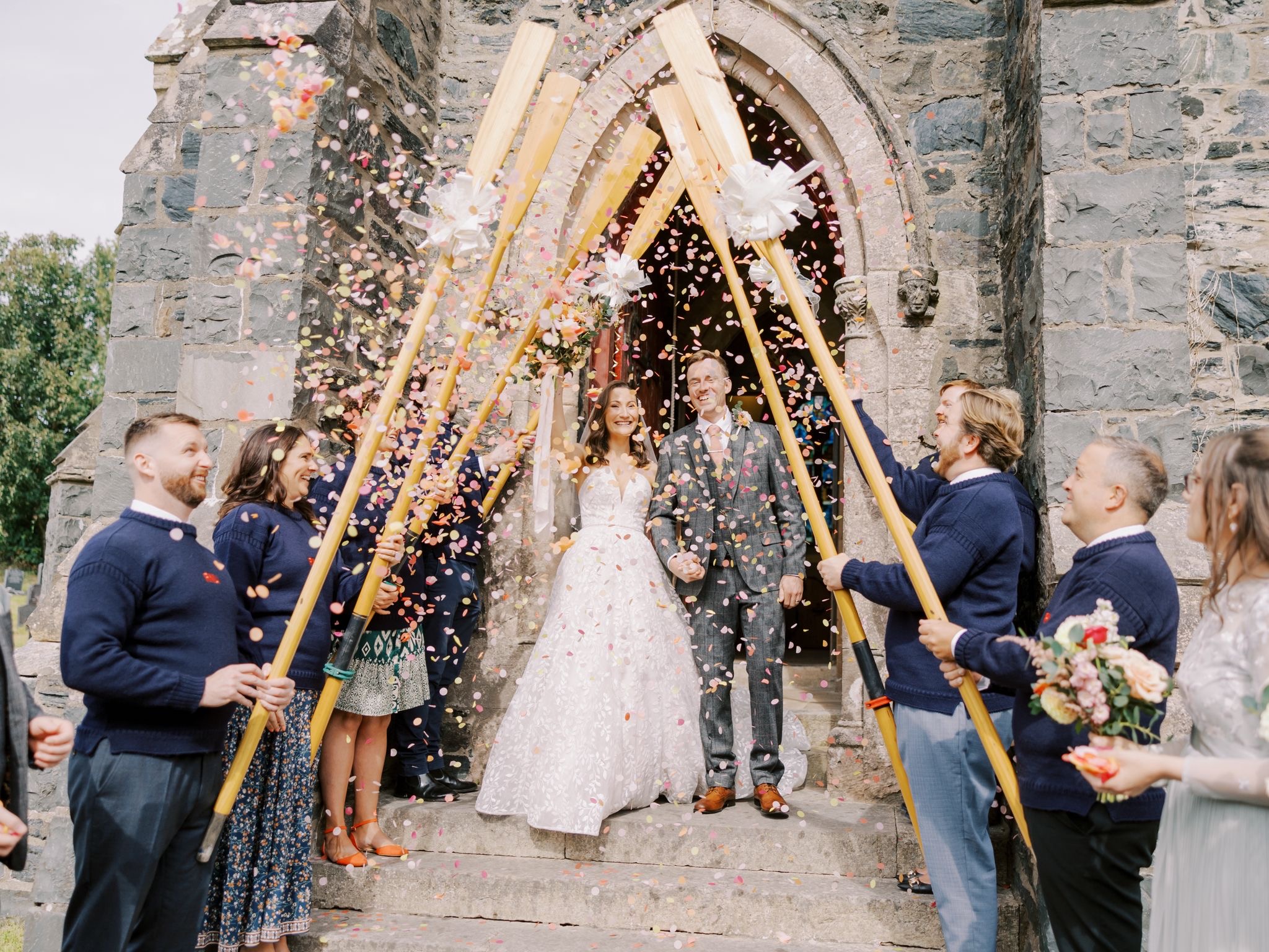 The couple can be seen leaving the church with crew members lining both sides of the steps forming a guard of honour with the oars.