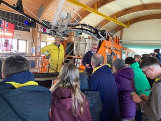 A crew member on the ALB showing a group of scouts the ALB within the offshore boathouse