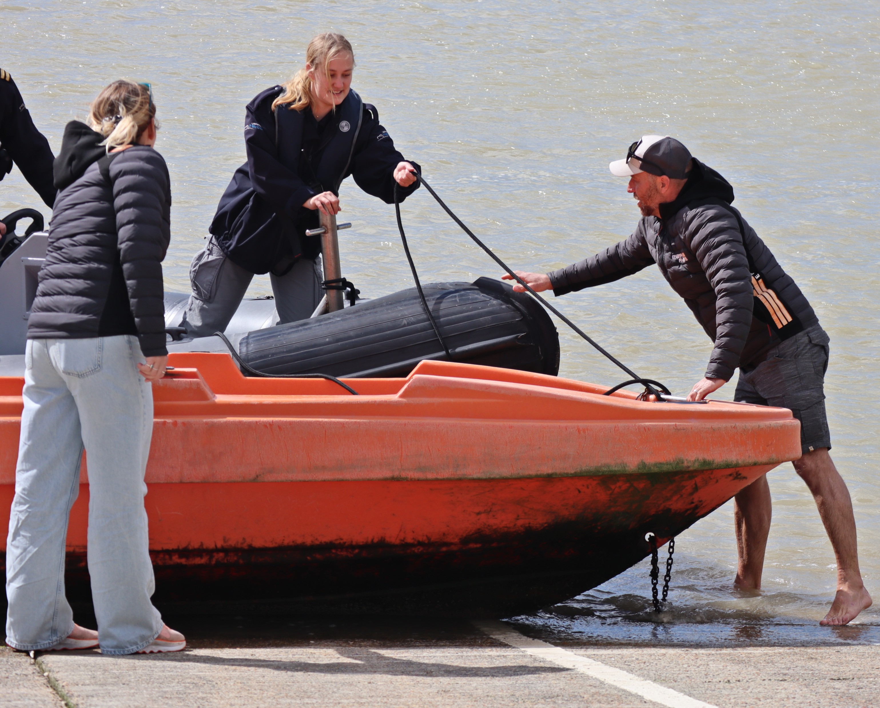 RNLI Crew member, Sophie Collins, in her Littlehampton Harbour Board role passing Izzy’s painter to the Easy Rider team.