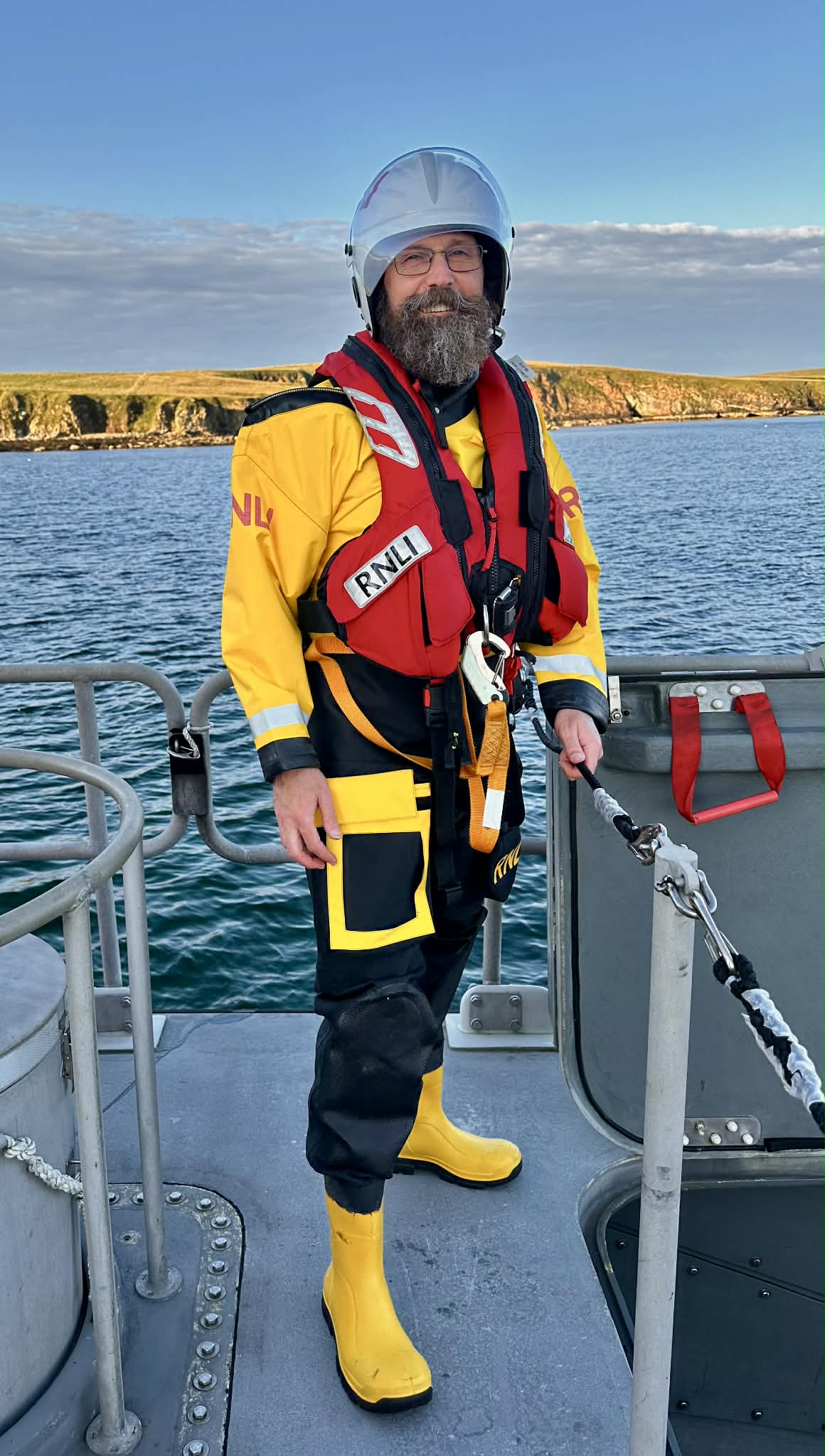 Gavin stands on the deck of RNLI Helen Comrie