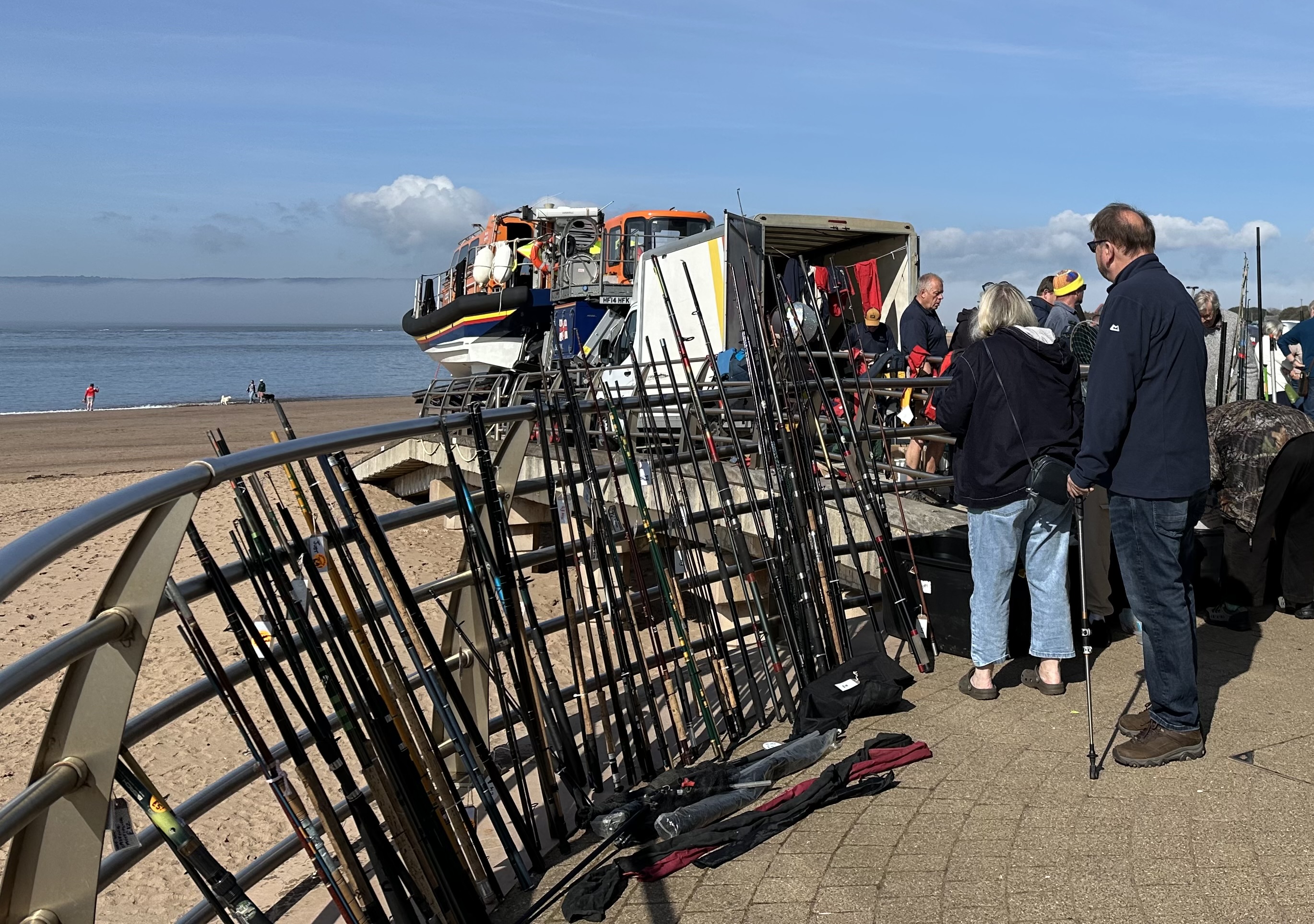 Exmouth RNLI's Boat Jumble event in action in 2025 showing a large amount of fishing gear for sale and the all-weather Shannon class lifeboat on the ramp in the background