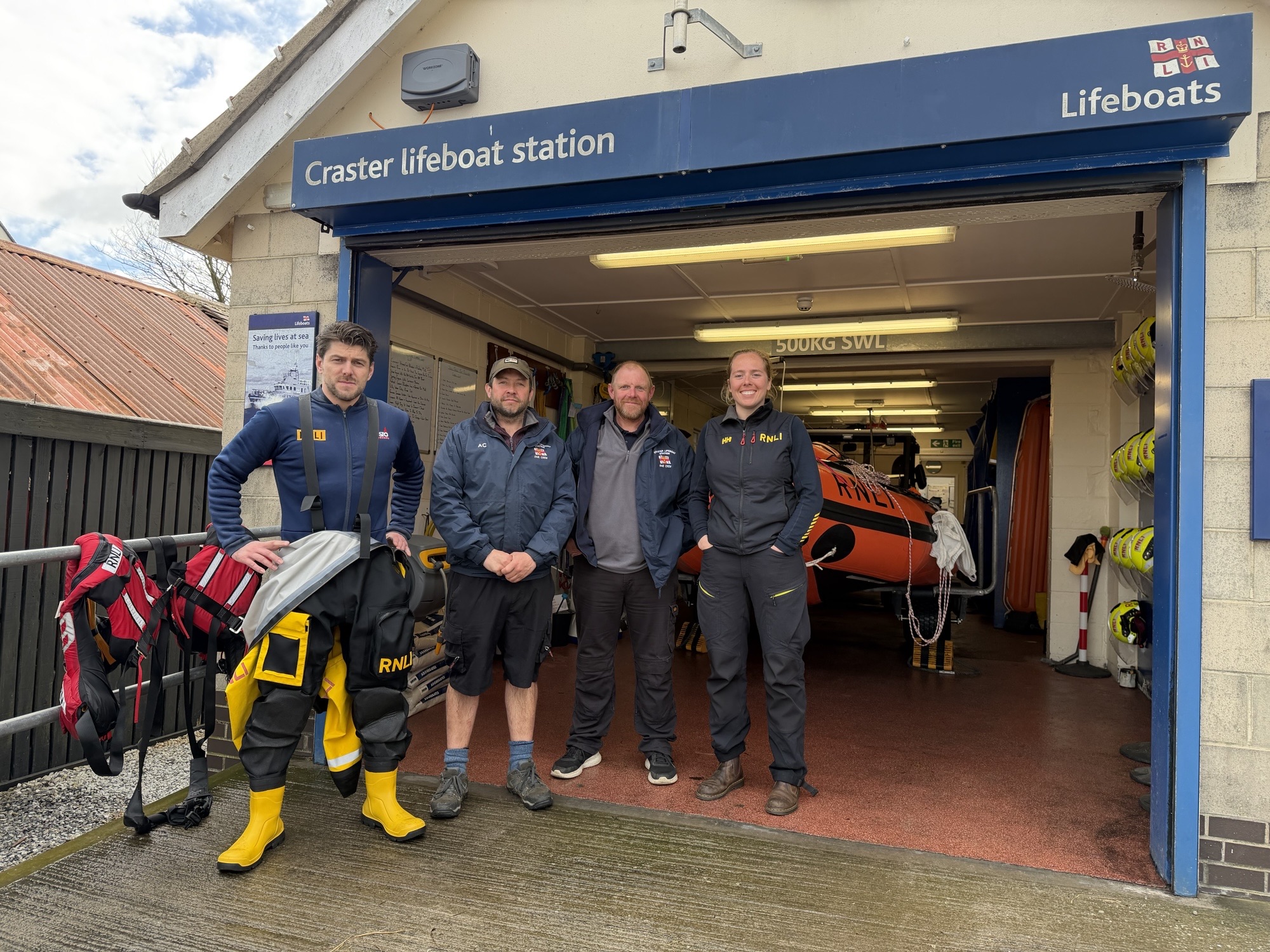from left to right David Kearns, Andy Cowan, Andy Taylor and Costal lifeboat Trainer, Anna Hislop-Latif standing in front of Craster Lifeboat station