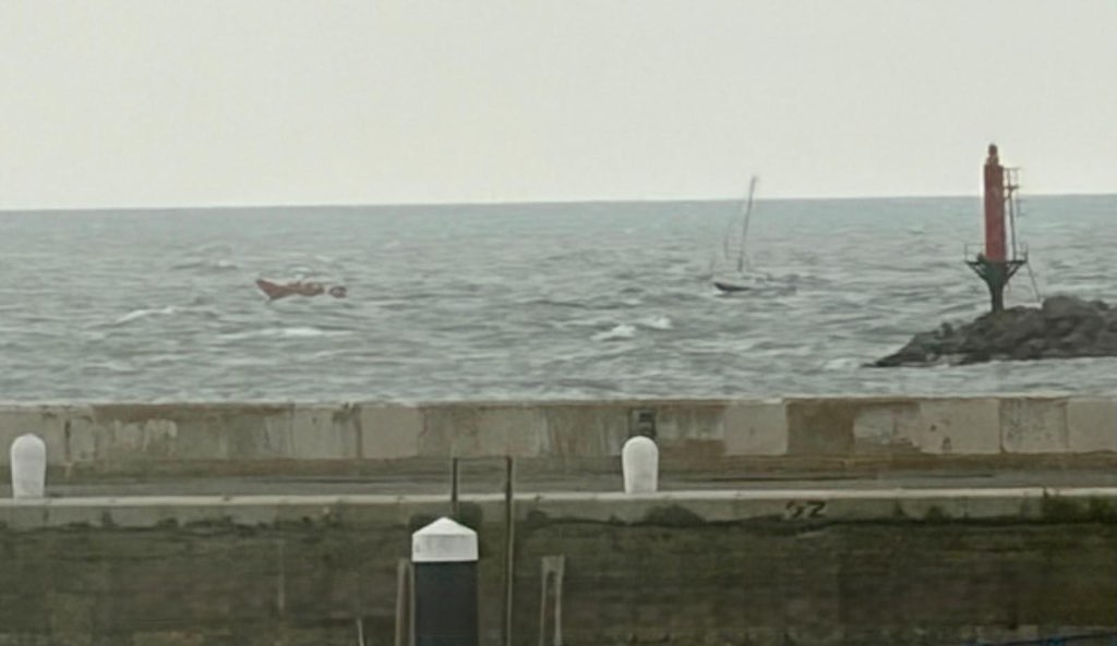 Walmer lifeboat towing vessel out side harbour wall grey skies and choppy seas