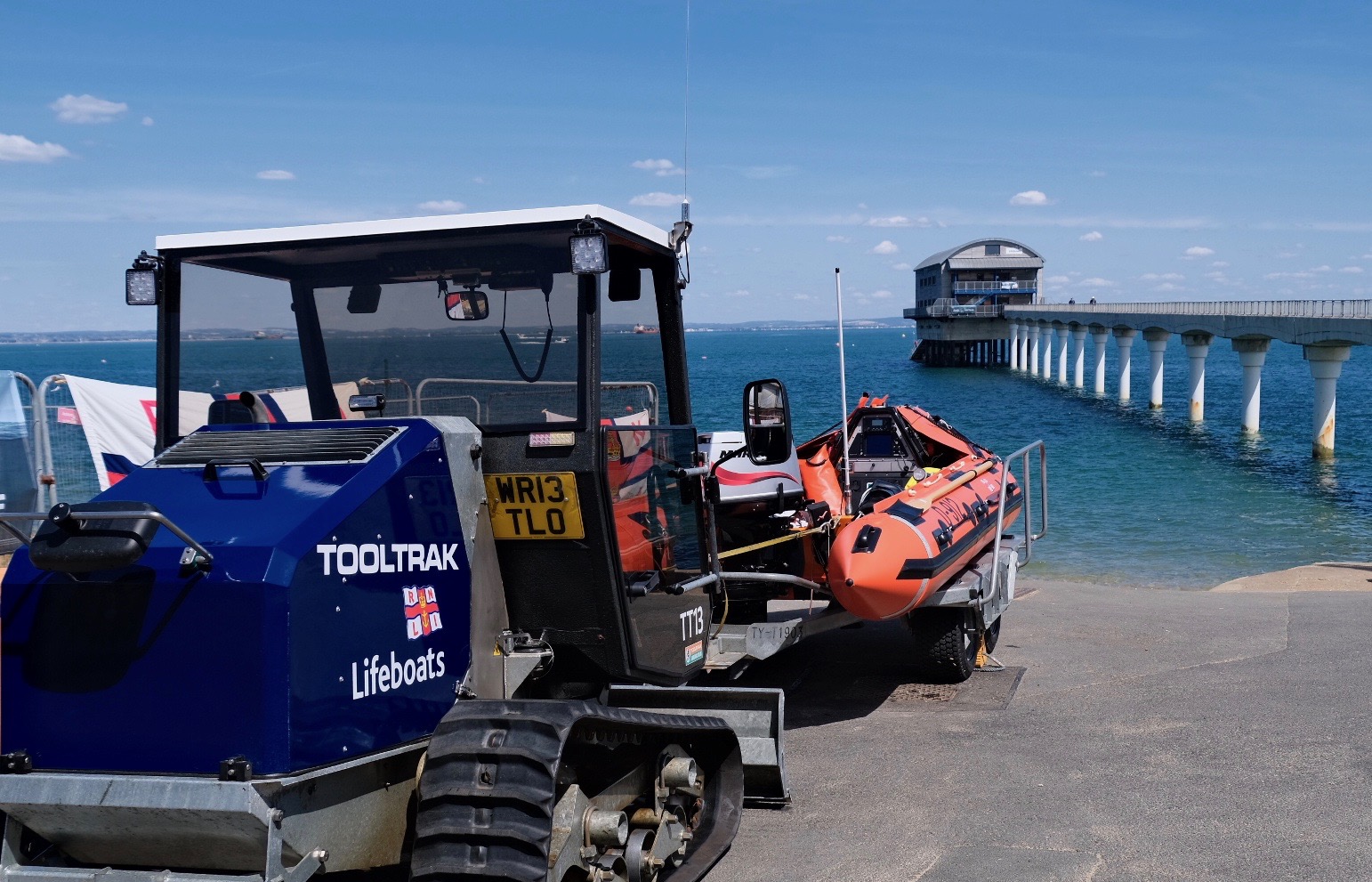 Inshore lifeboat Sue attached to the launch tractor by the slipway with Bembridge offshore boathouse in the background
