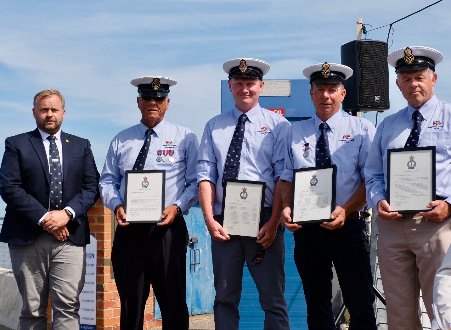 Line up of RNLI personnel with their commendation awards