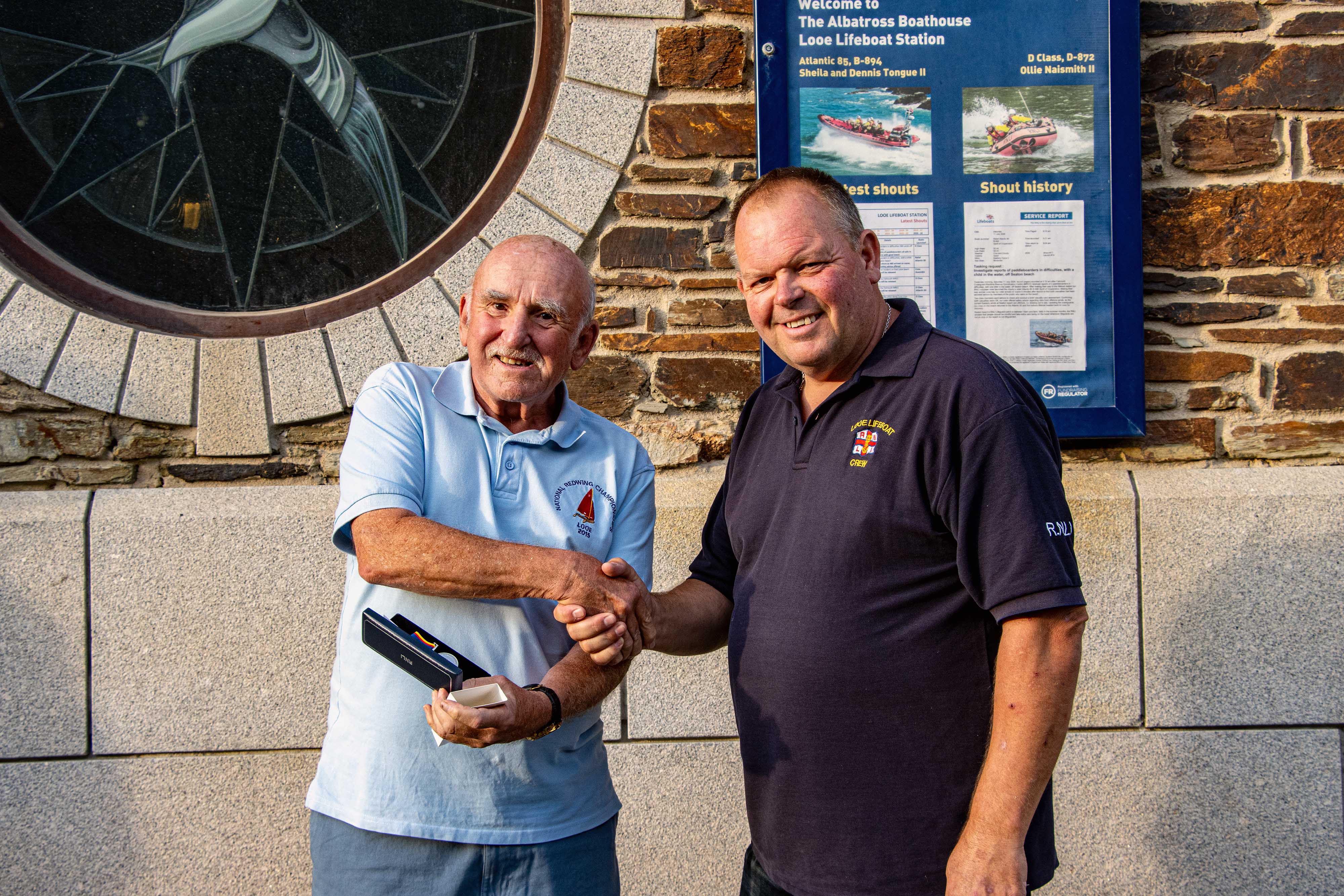 Looe RNLI Lifeboat Operations Manager Clive Palfrey congratulating Paul Sedgbeer on his 20 year long service with RNLI Looe Lifeboat Station