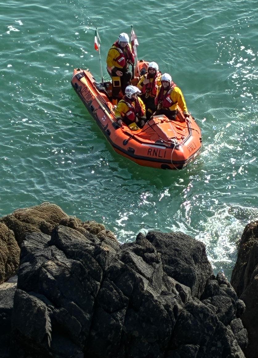Tramore RNLI lifeboat under the cliffs at Tramore with 4 crew on board