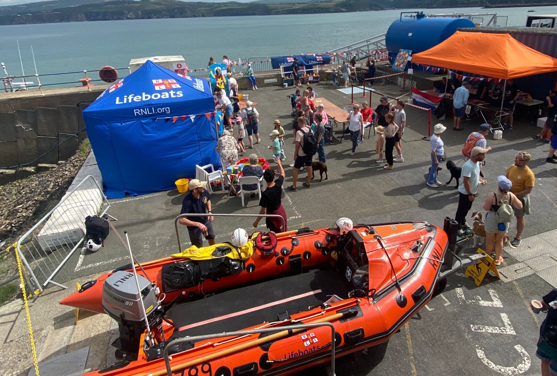 View from the lifeboat station of the inshore lifeboat and people enjoying the 2025 Open Day.
