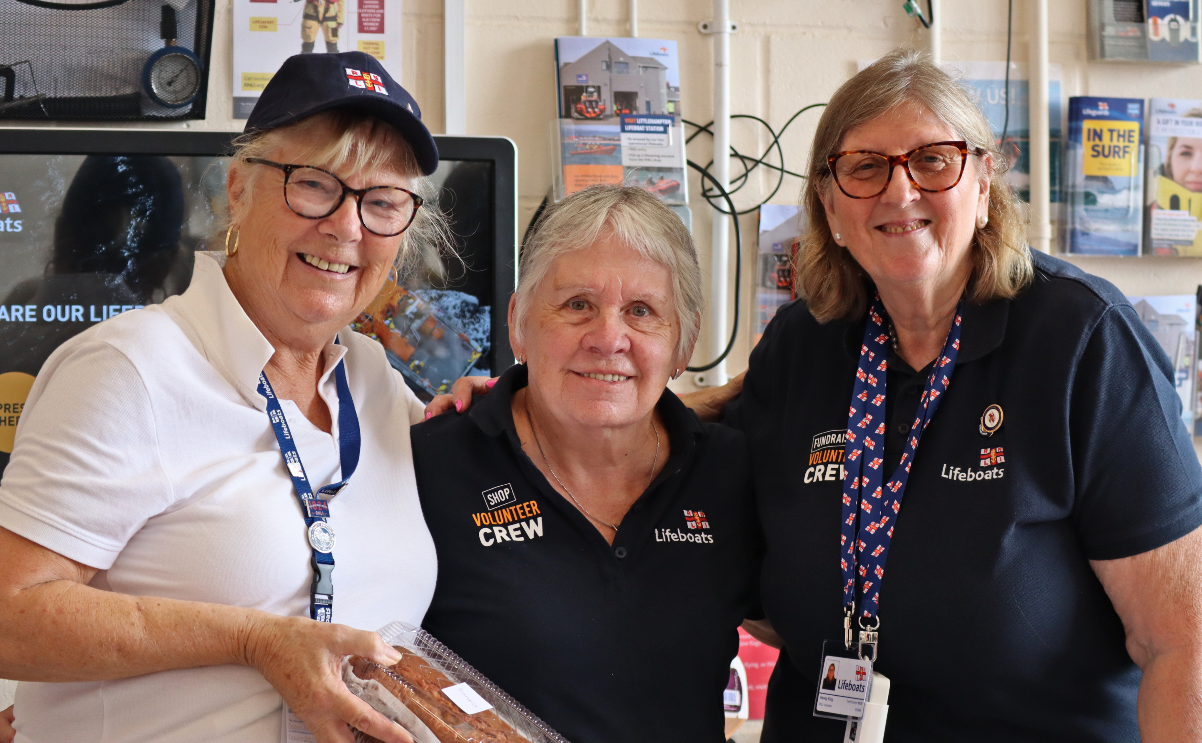 Three volunteers smile as they pose for a group photo