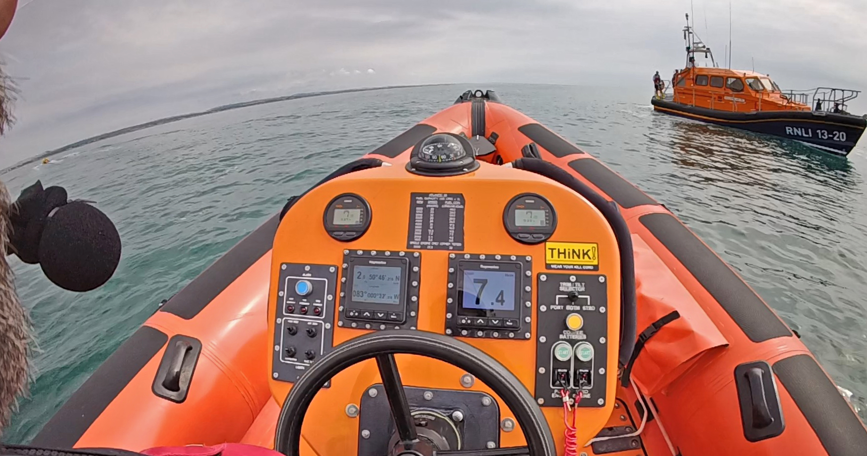 A view from a helmet cam of the helm of a boat looking at a lifeboat