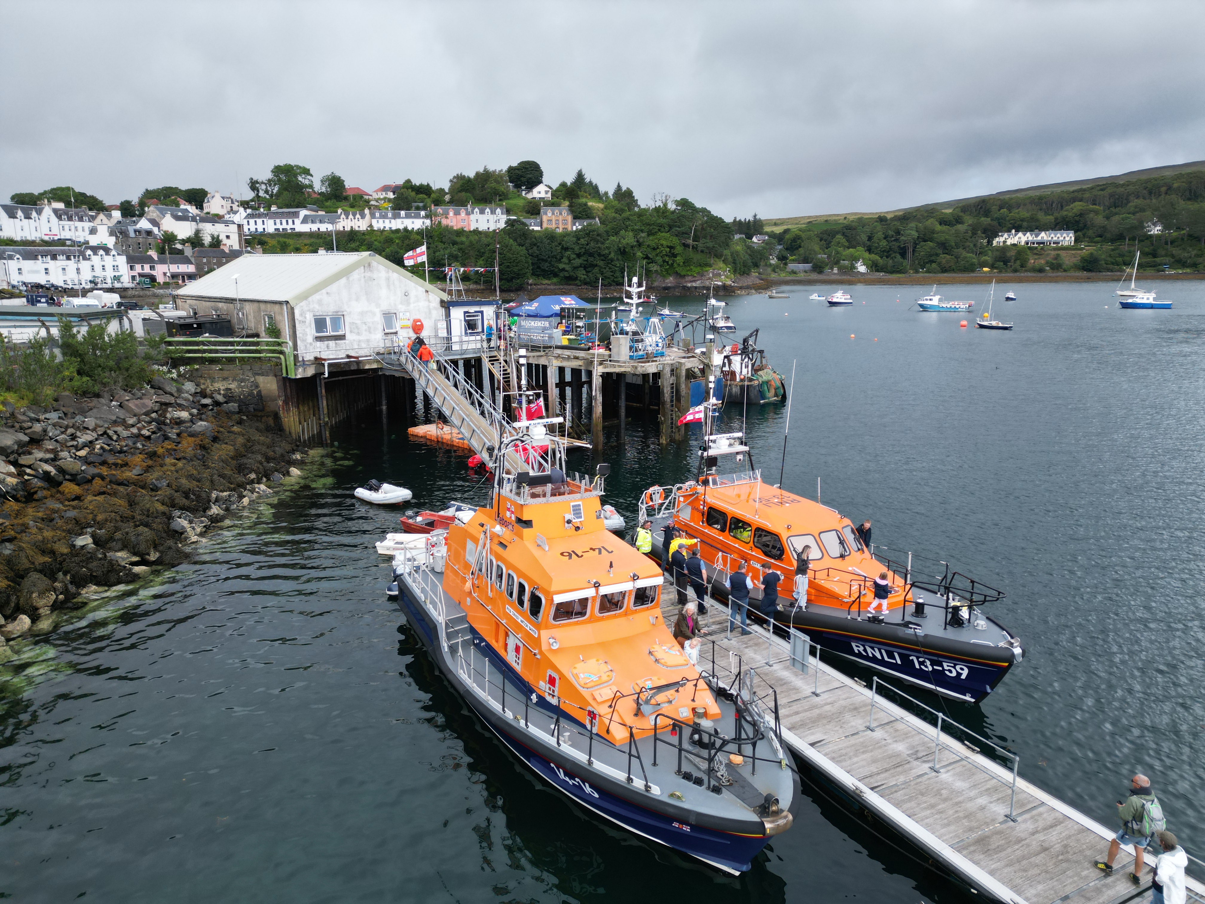 The retiring Portree RNLI lifeboat pictured alongside Portree pontoon with the brand new vessel Peter and Mary