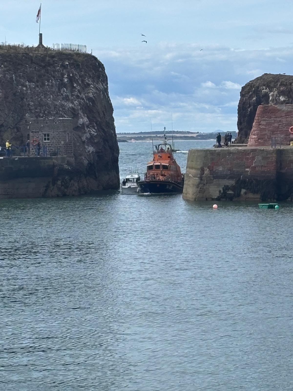 Two boats enter harbour.
