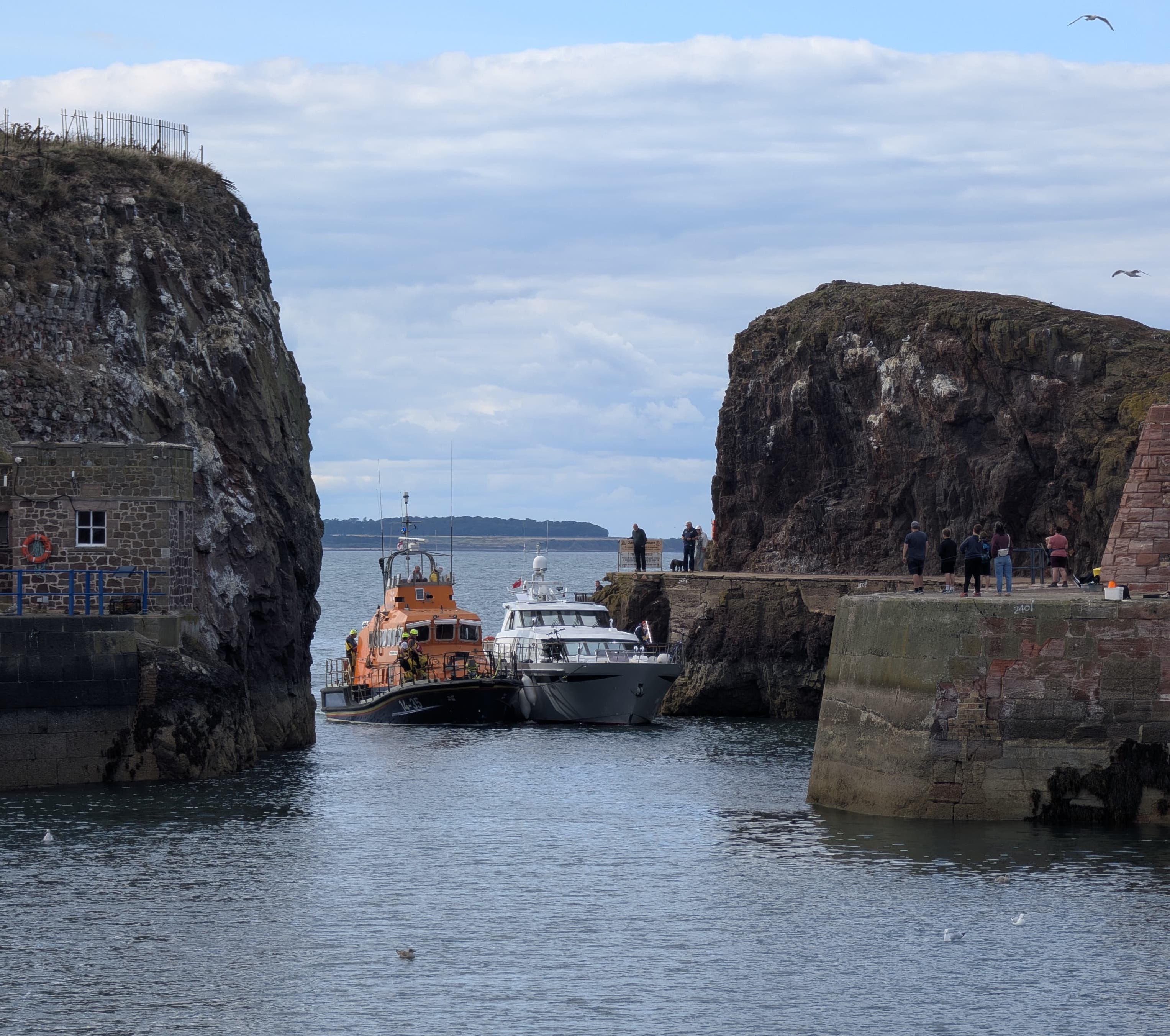 Two boats enter harbour.