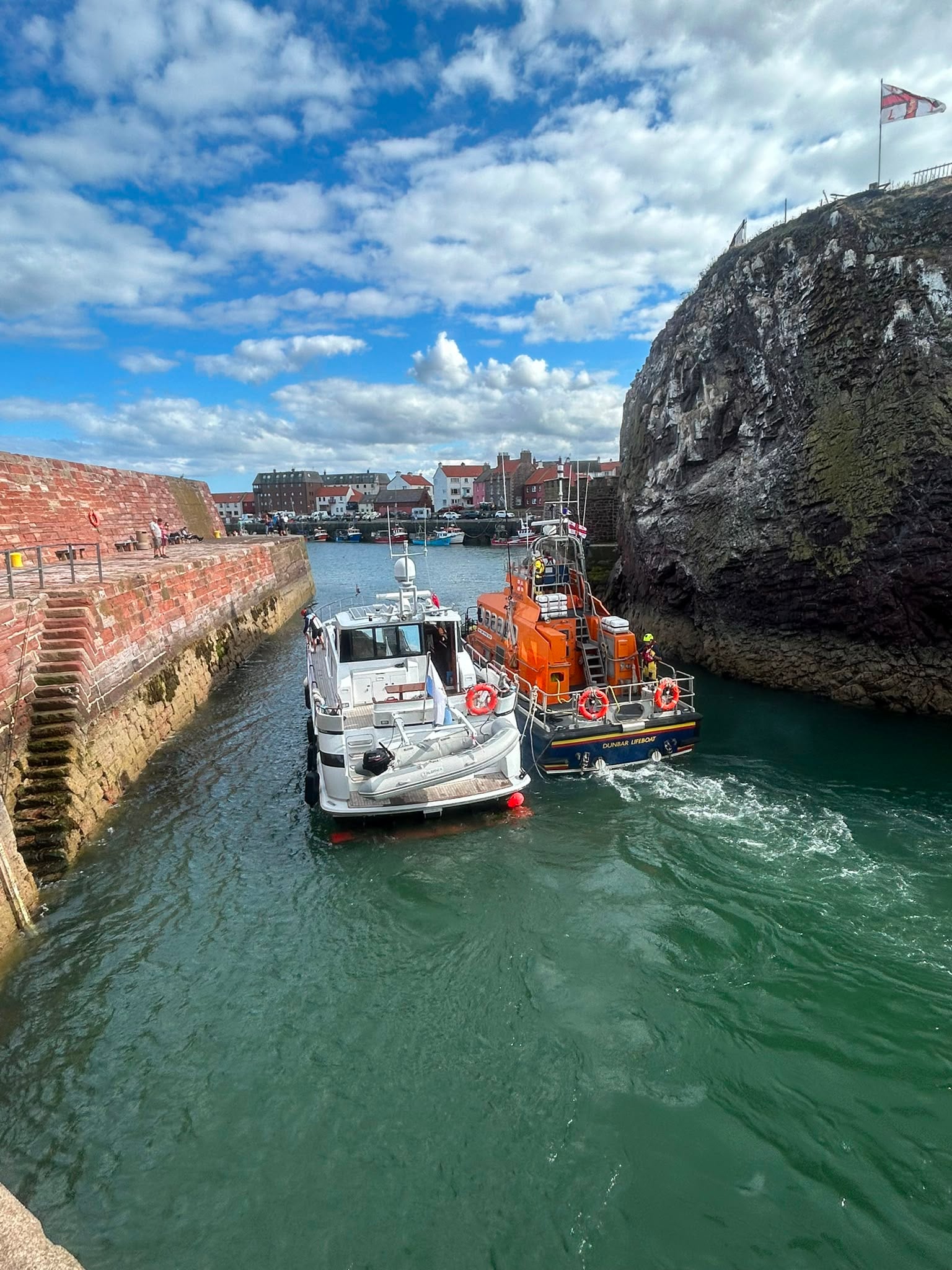 Two boats enter harbour.