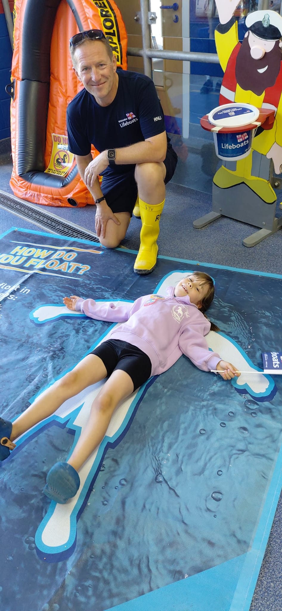 Freya Partington, six learns about 'Float to Live' with Alistair Barrett, launch authority during Emergency Day at Whitstable RNLI.