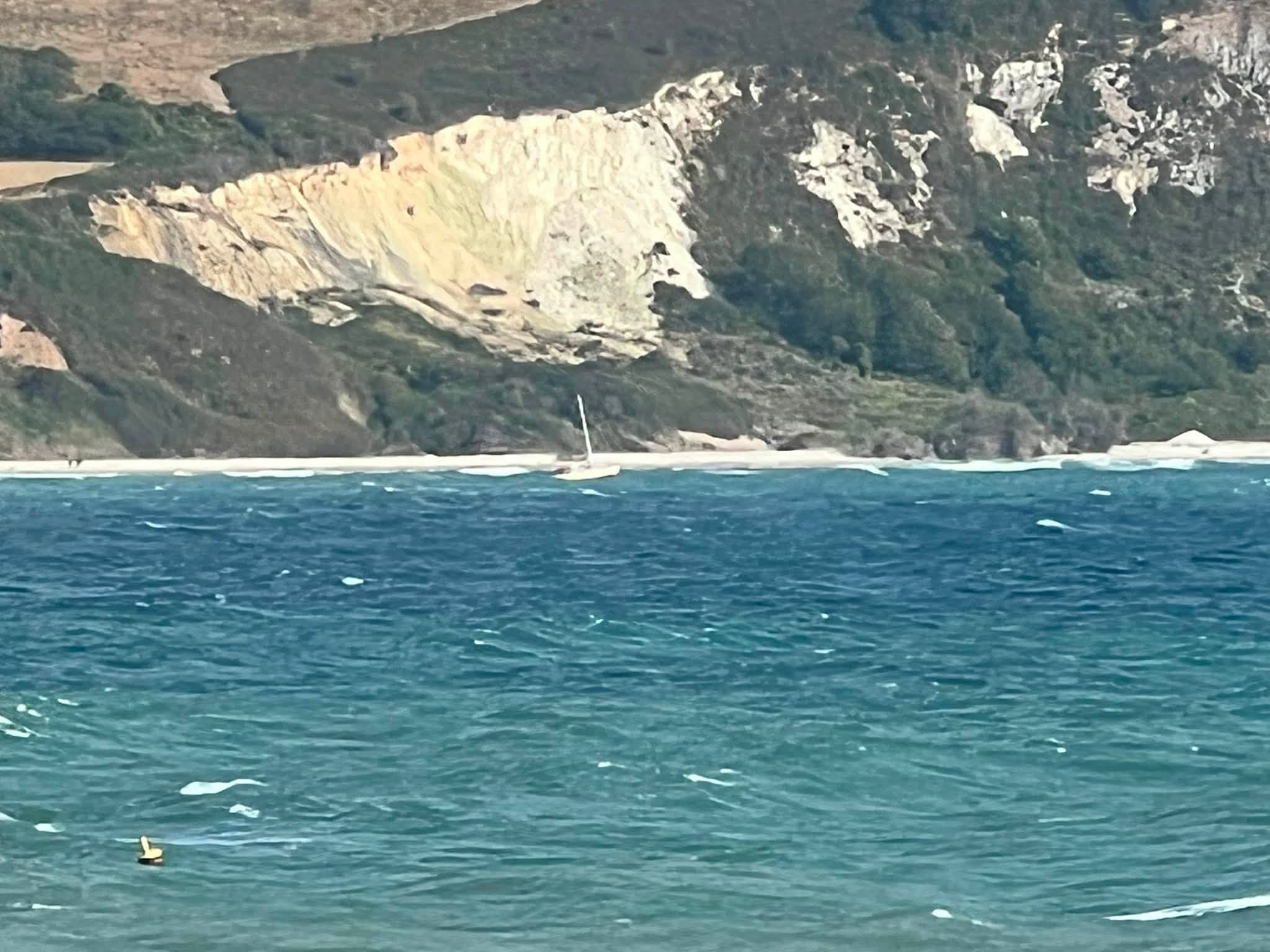 Yacht at anchor in Swanage Bay as swell increases due to easterly wind