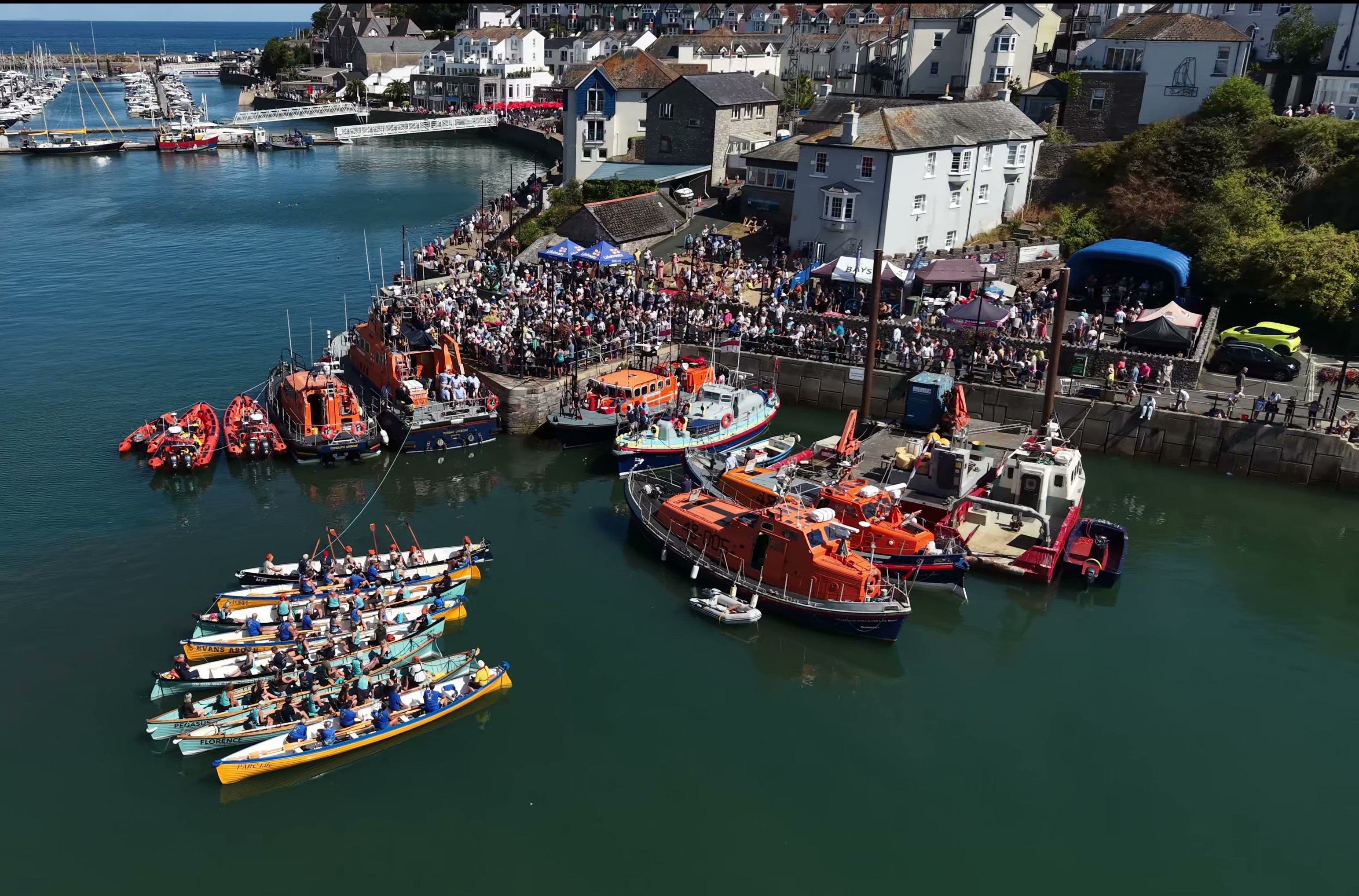The assembled gig boats and lifeboats at Brixham's Man and Boy Statue