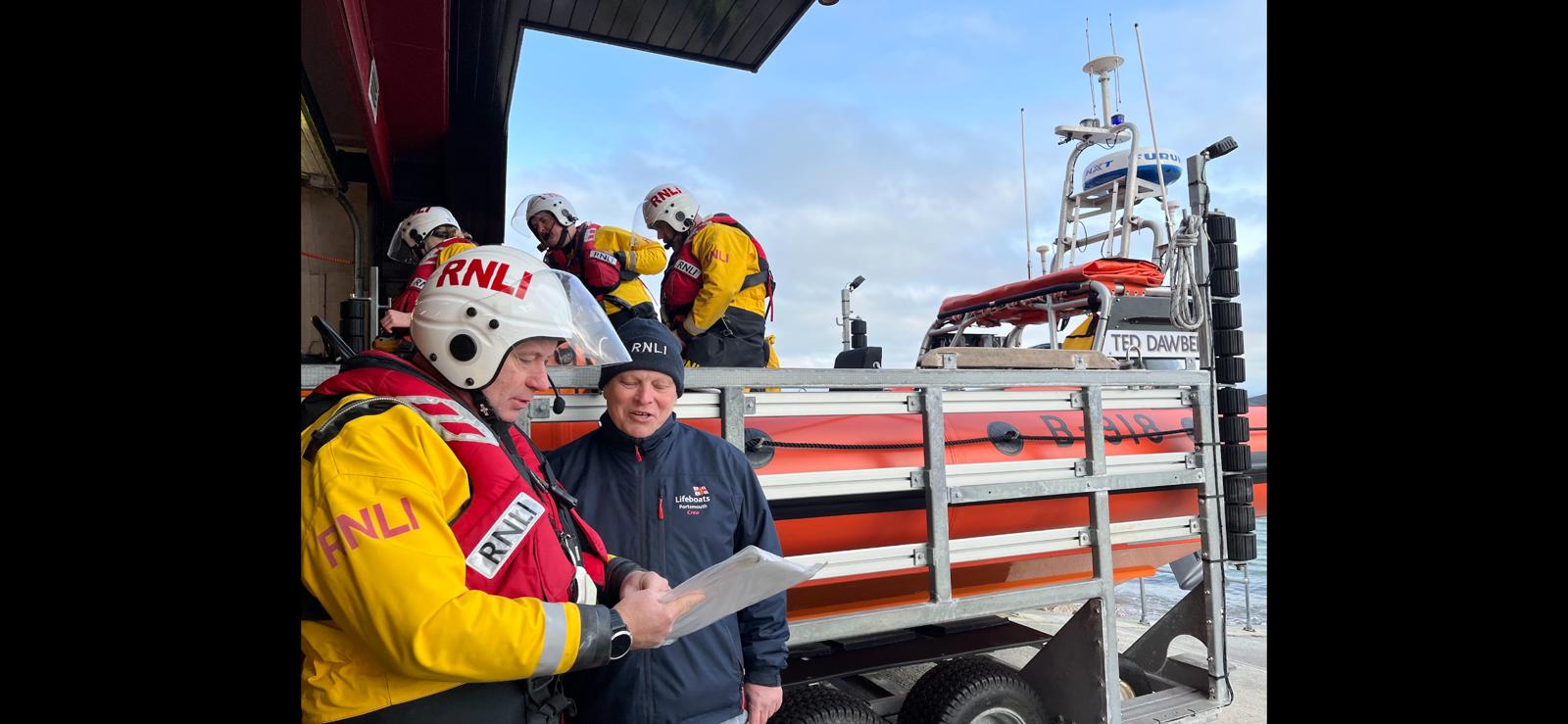 Lifeobat Helm and launch authoority stadning in front of Lifeboat B-918 on its launch trailer
