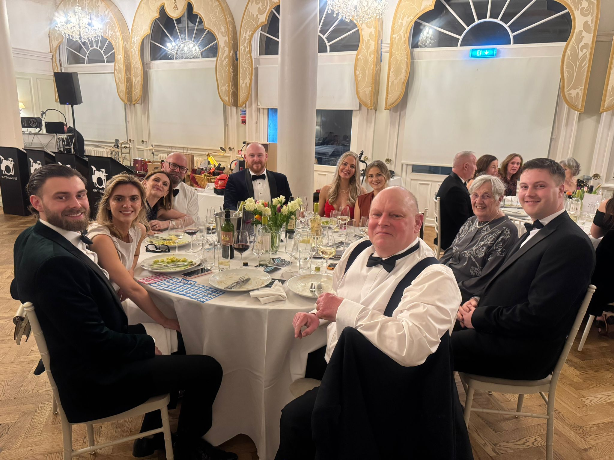 A table of guests at black tie dinner, with Andy Gissing in centre foreground