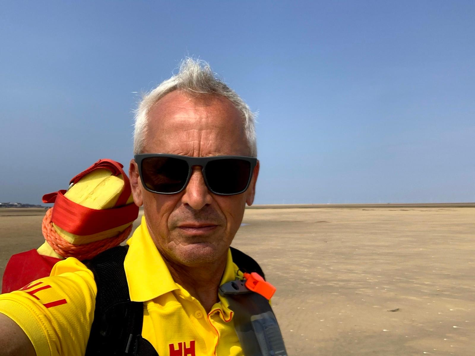 Richard on a sunny day at the beach in his RNLI lifeguard uniform. 