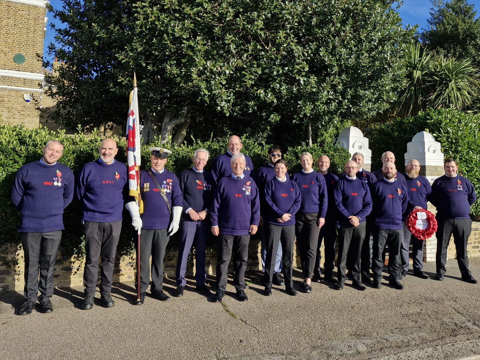 Tony bearing the charity's flag with fellow RNLI volunteers at 2025 Remembrance parade