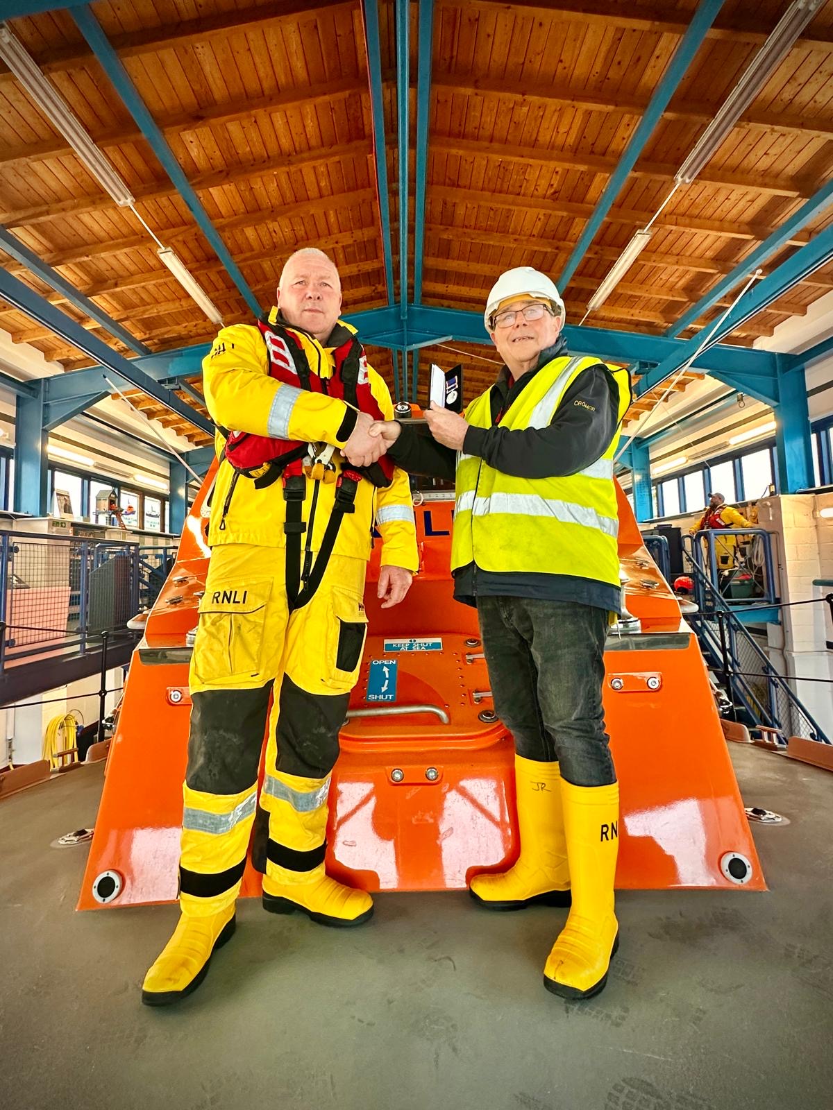 Gordon Nichols receiving award from Cromer RNLI volunteer lifeboat operations manger John Redmond