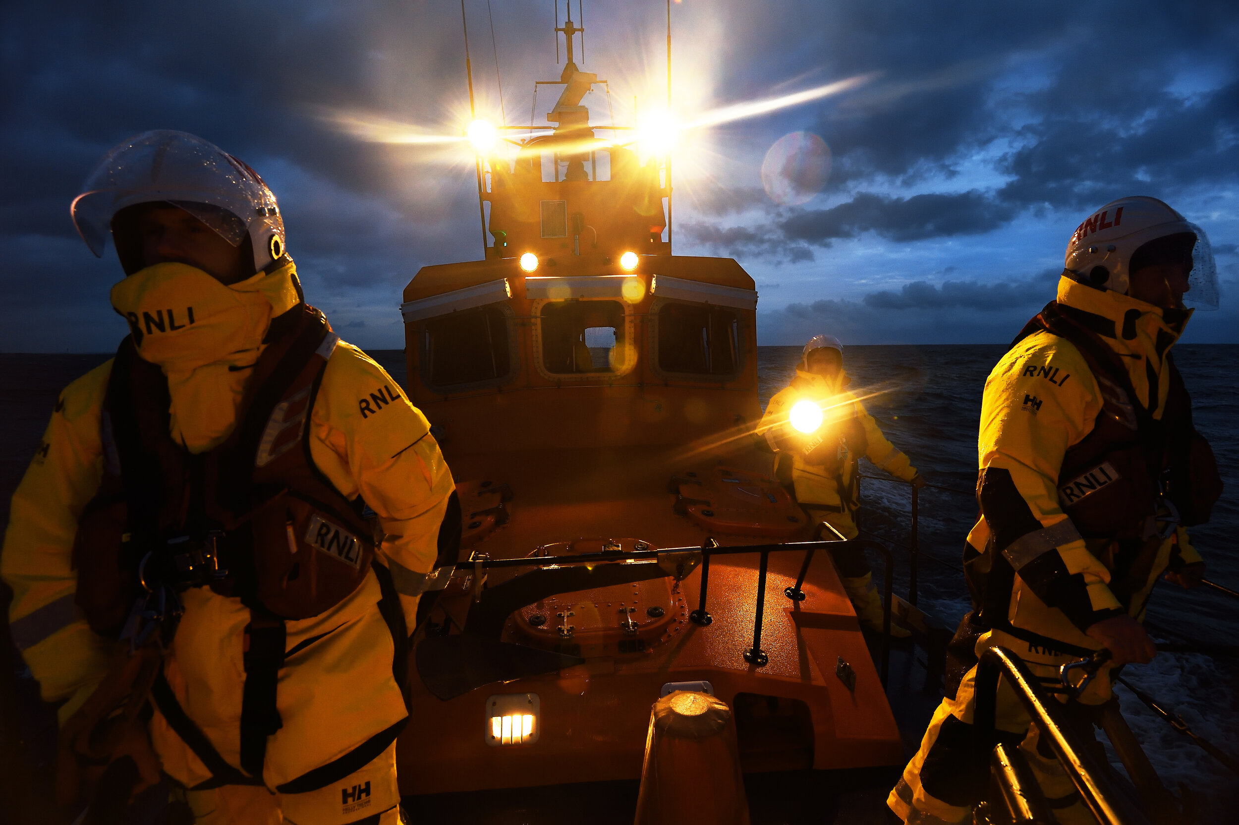 Three men on a boat at night