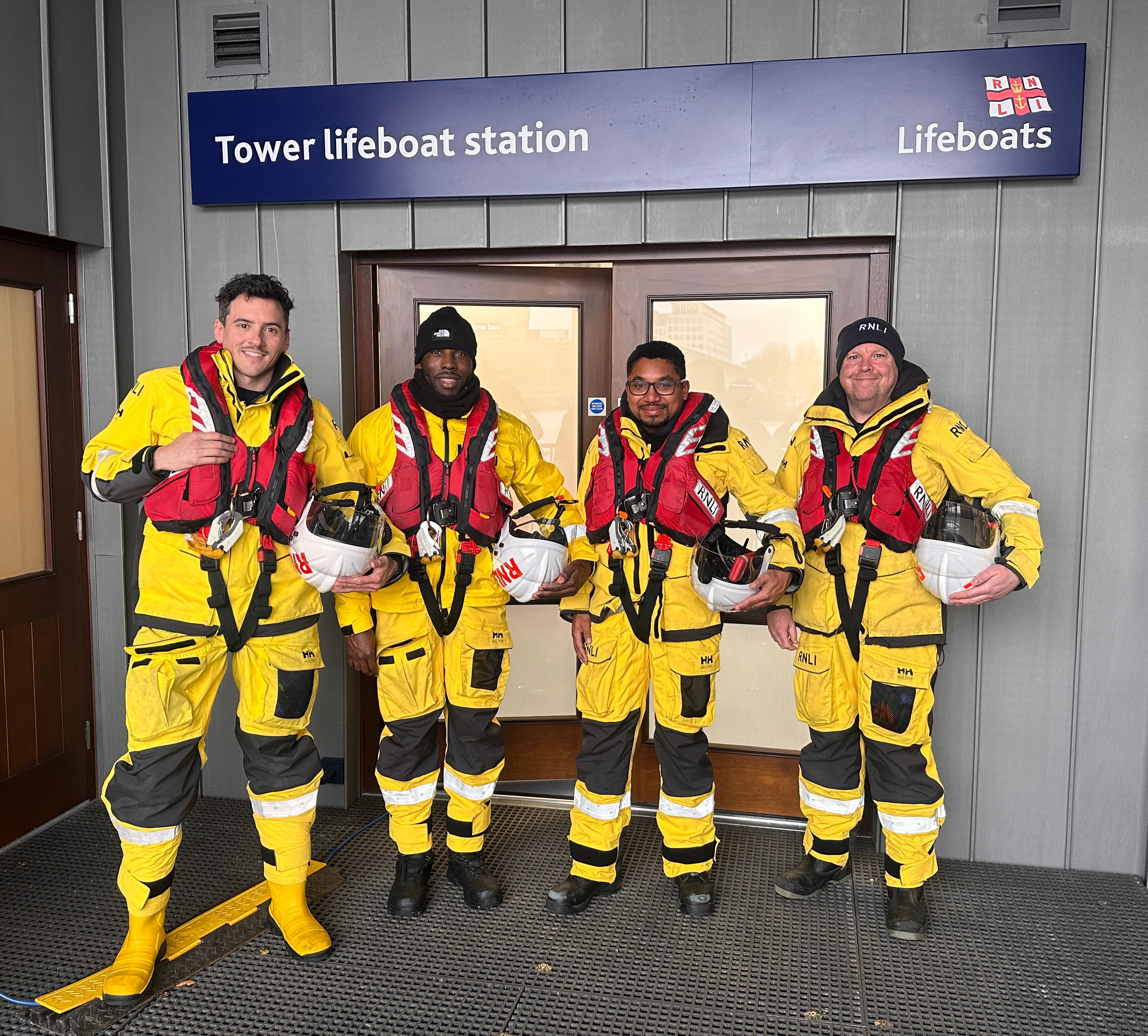 The four volunteers stand in their yellow kit prepared to go afloat