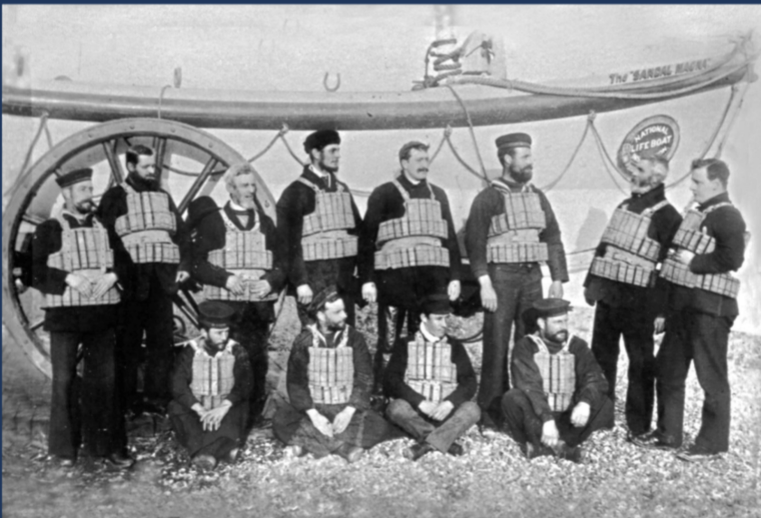 A black and white old picture of a group of RNLI crew members in front of the Sandal Magna lifeboat in the early 1890s