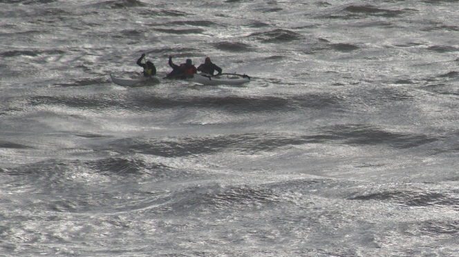People in the water waving for help.