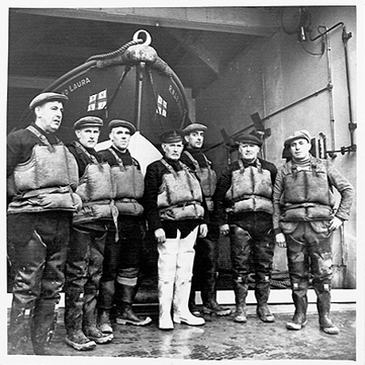 Crew in front of lifeboat outside boathouse