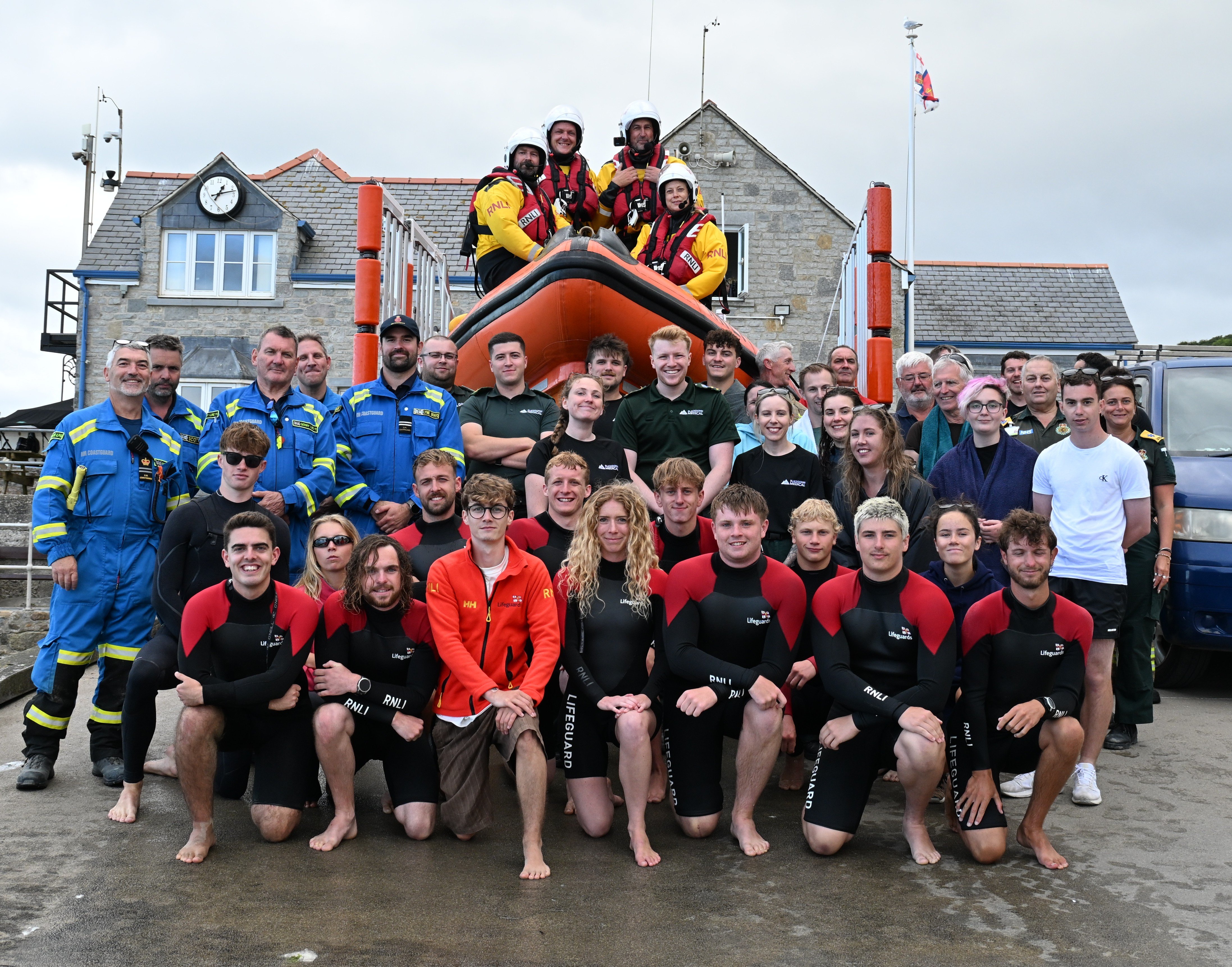 Group of people from various agencies in front of Lyme Regis lifeboat