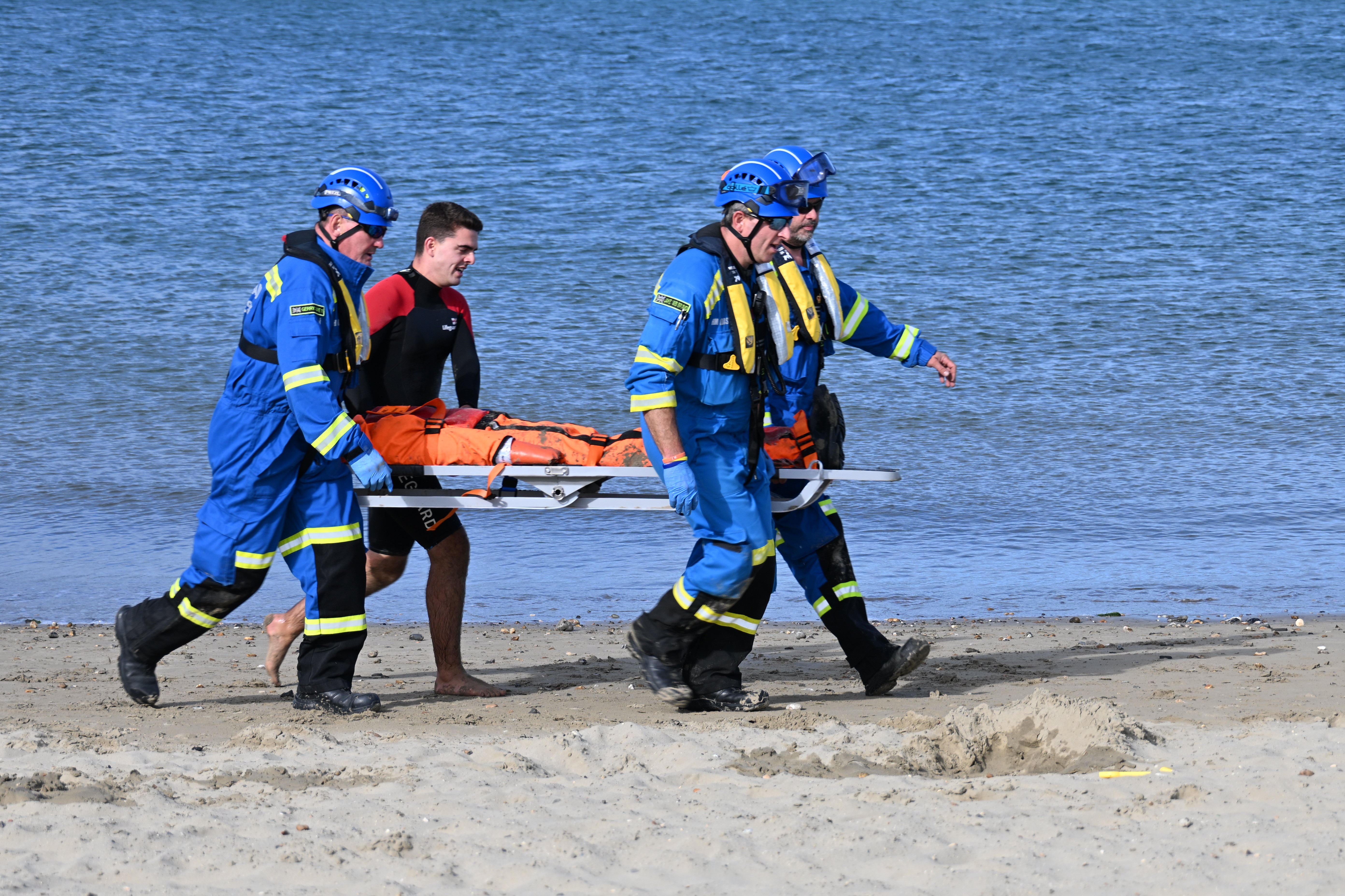 Four people carrying a stretcher