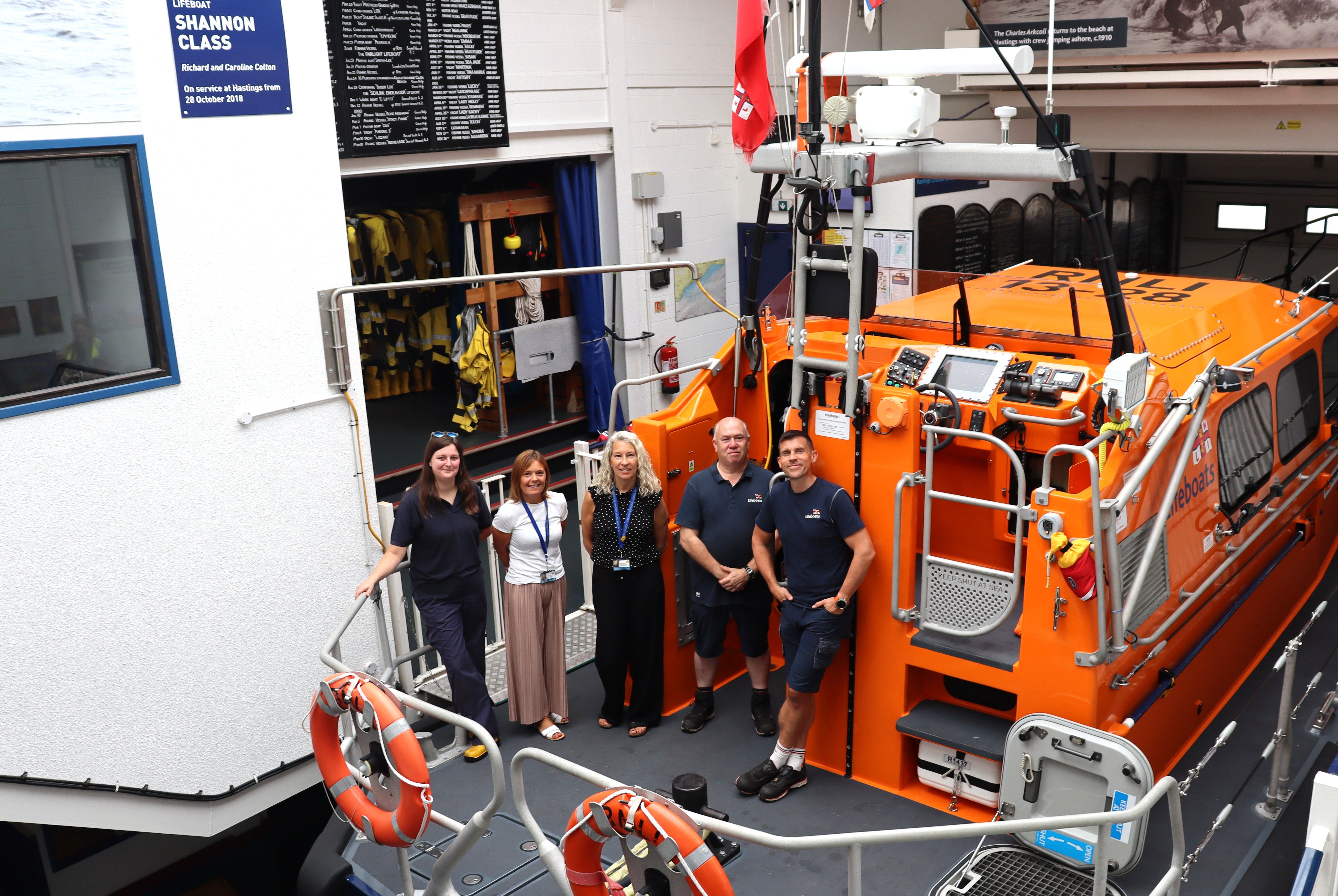 Group of RNLI staff/volunteers with FSN charity representatives on Hastings Lifeboat