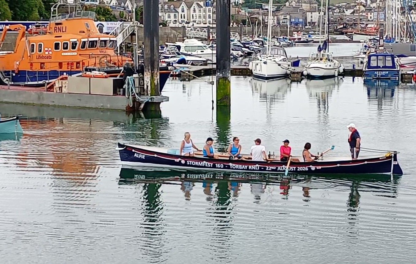 The wrapped gig boat with Torbay RNLI's Severn class All-weather lifeboat in the background