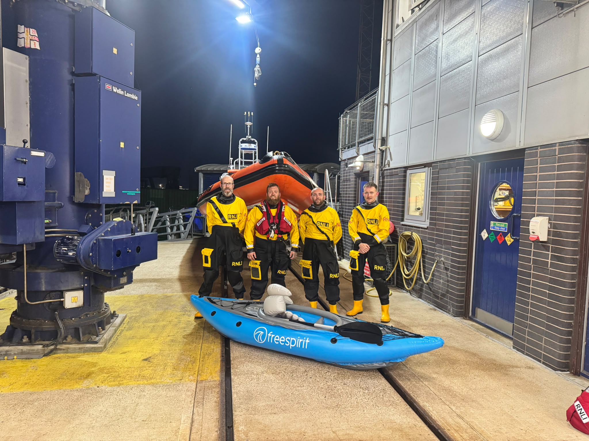 Harwich volunteer lifeboat crew after the rescue standing in front of the inshore lifeboat with one of the inflatable kayaks