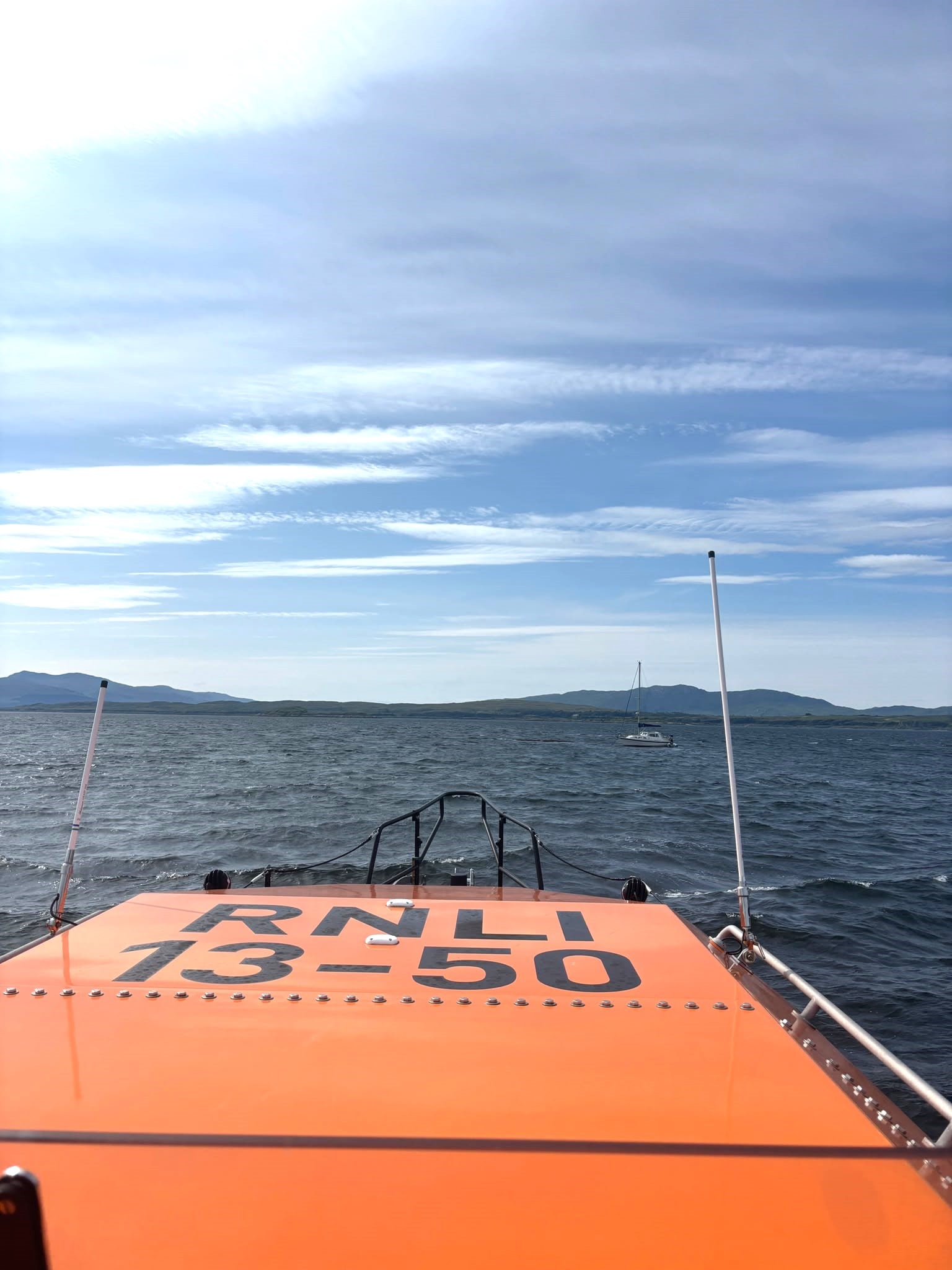 A photo taken from the raised outside bridge of the lifeboat across to the small yacht