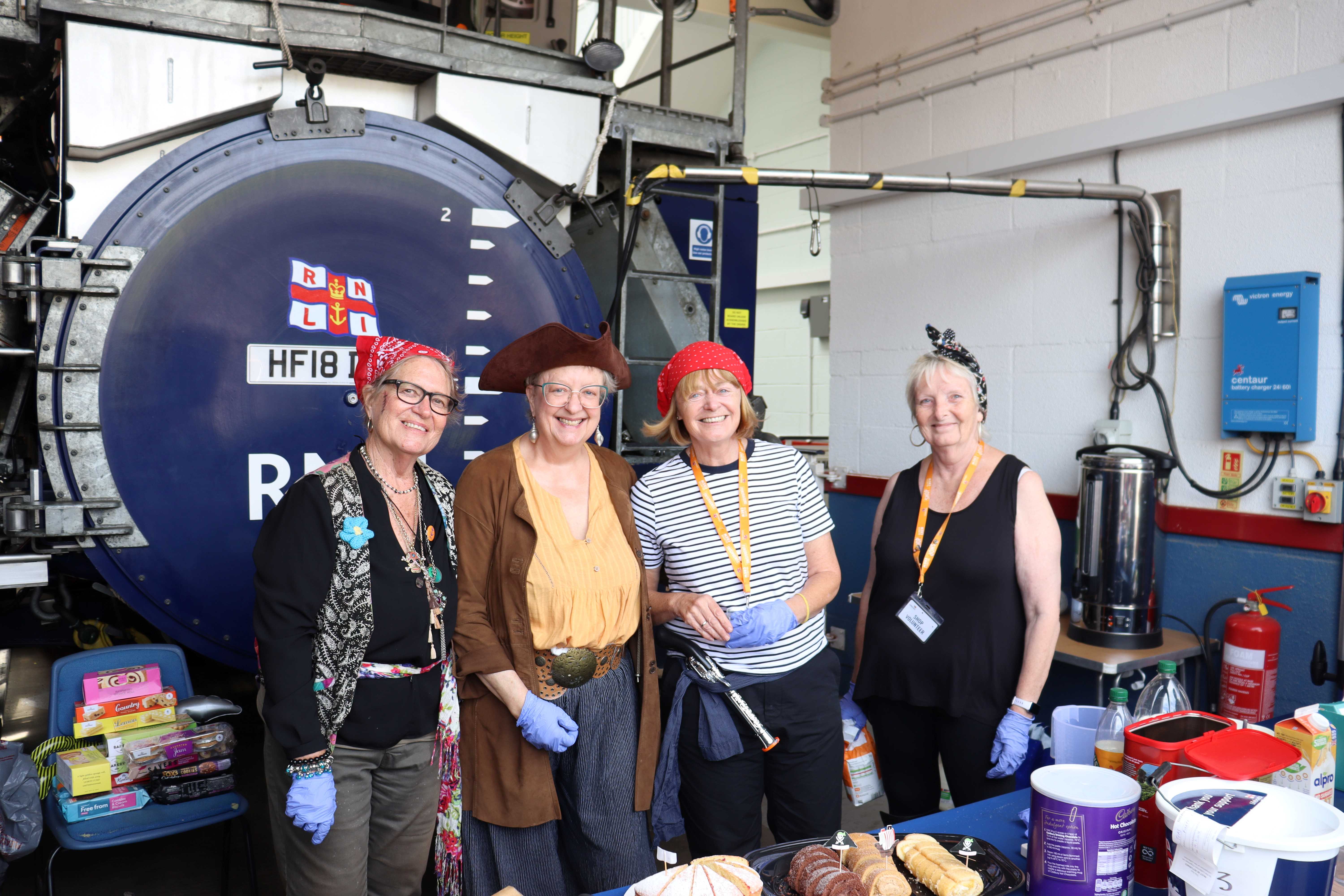 Four volunteers dressed as pirates in front of the lifeboat tractor