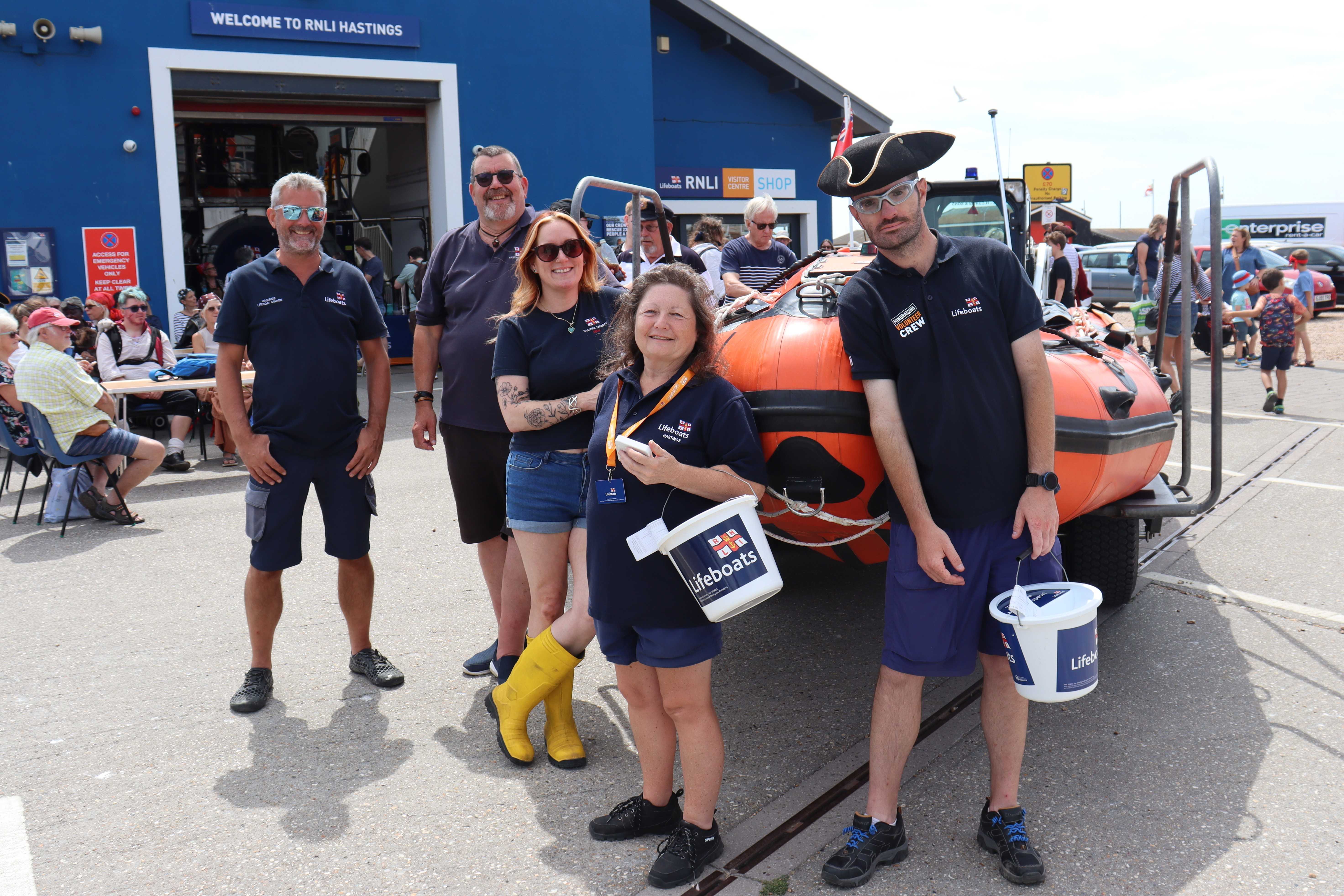 Five volunteers standing in front of the D class lifeboat in front of Hastings lifeboat station
