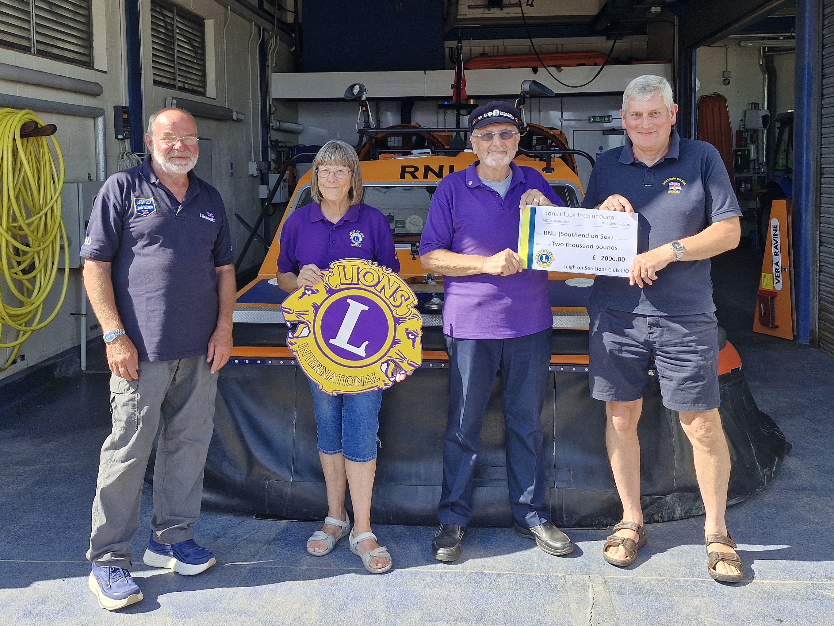 Leigh Lions present funds raised to Southend RNLI with Southend hovercraft in the background
