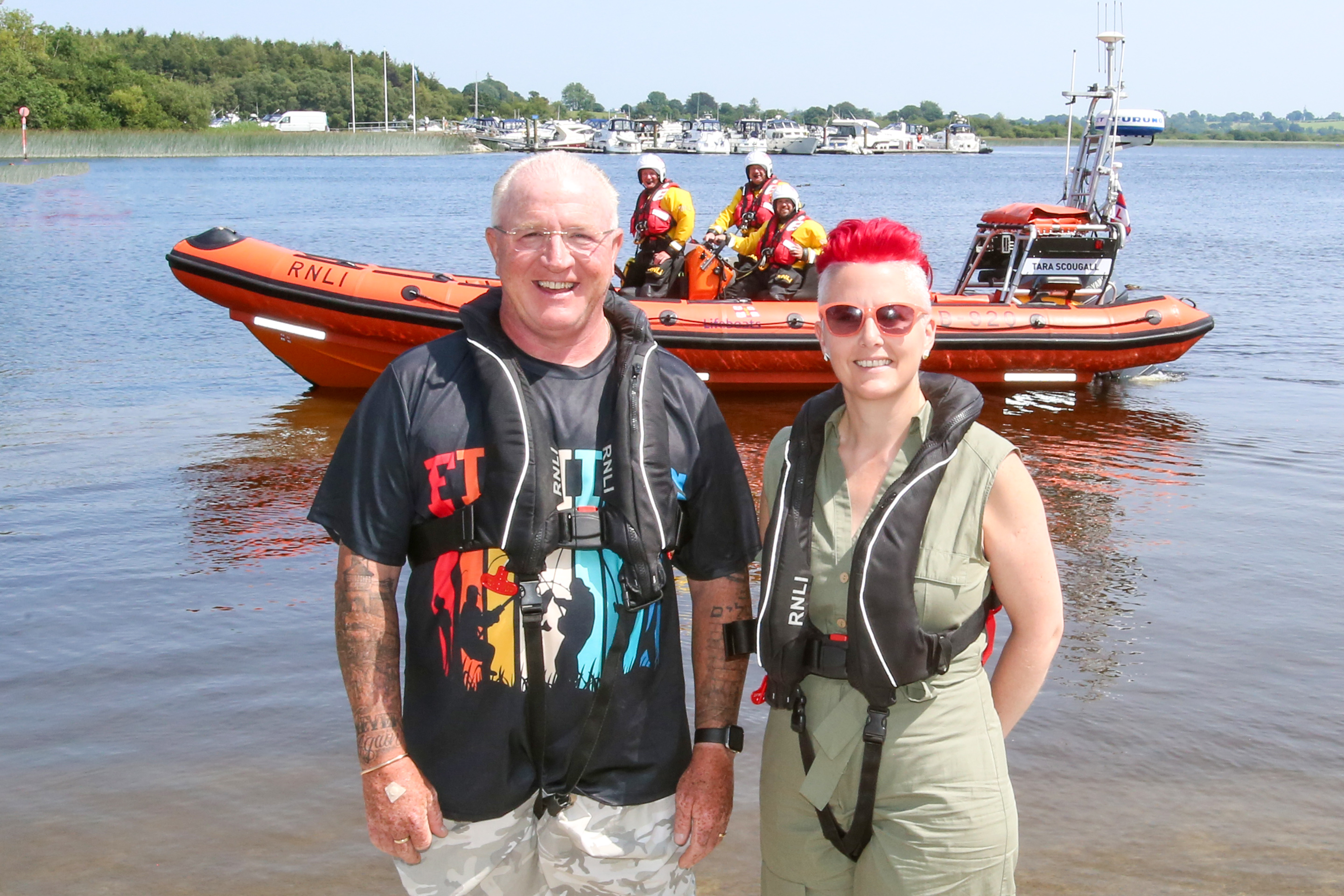 John and Lynda pictured at Lough Ree RNLI with the lifeboat and crew on the water in background