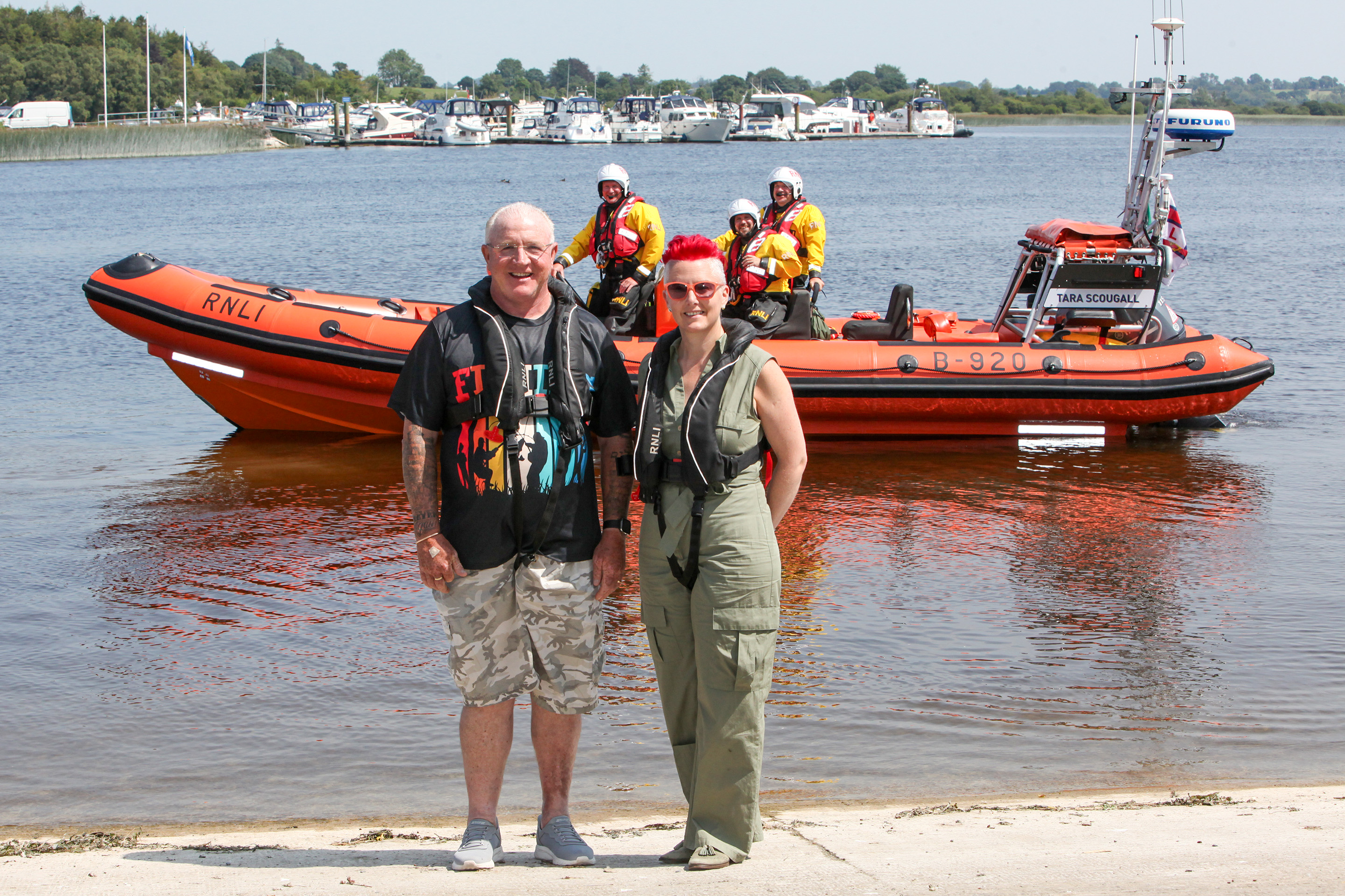 John and Lynda pictured at Lough Ree RNLI with the lifeboat and crew on the water in background