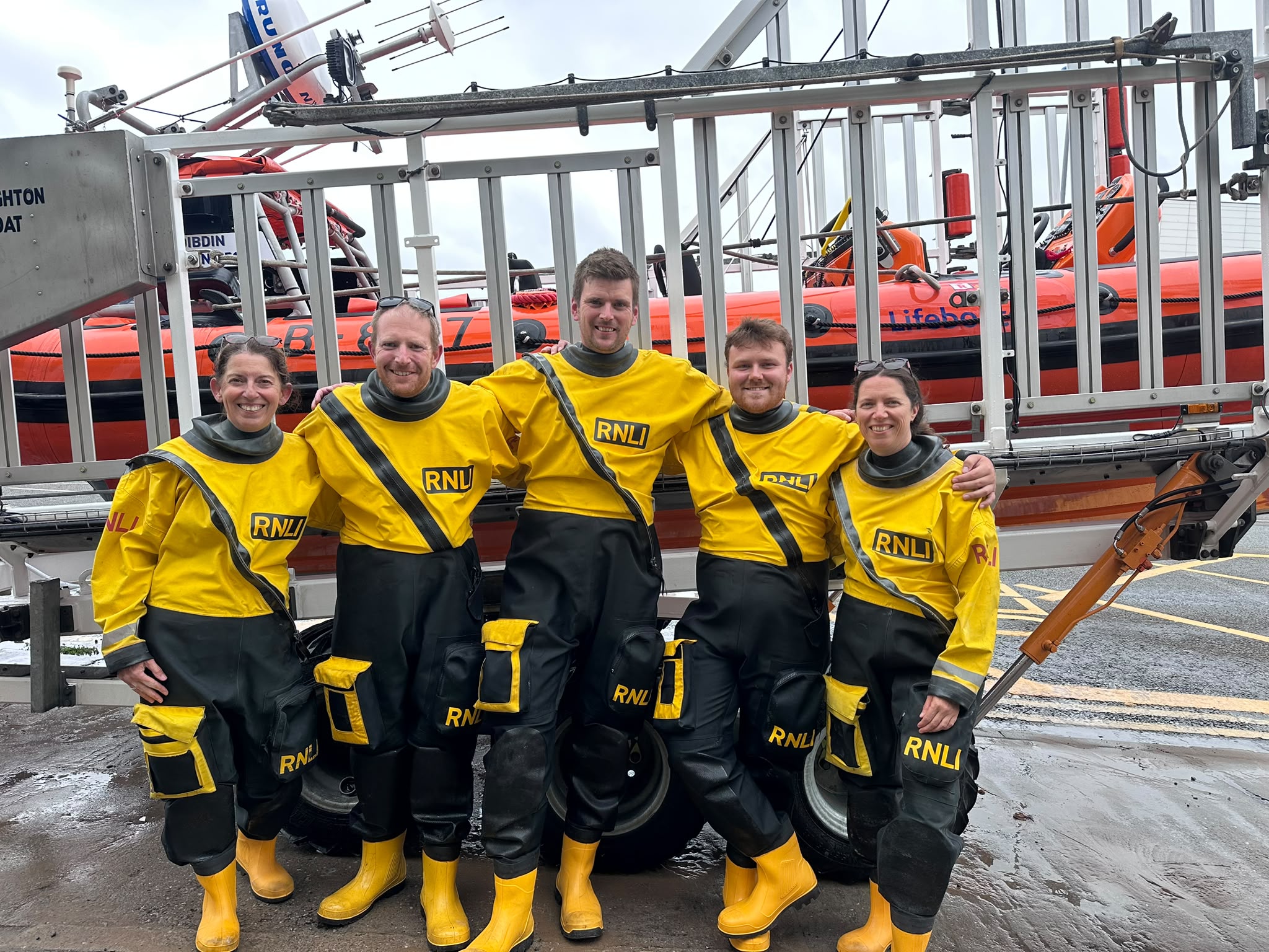 5 crew stood infront of the Atlantic 85 Lifeboat 