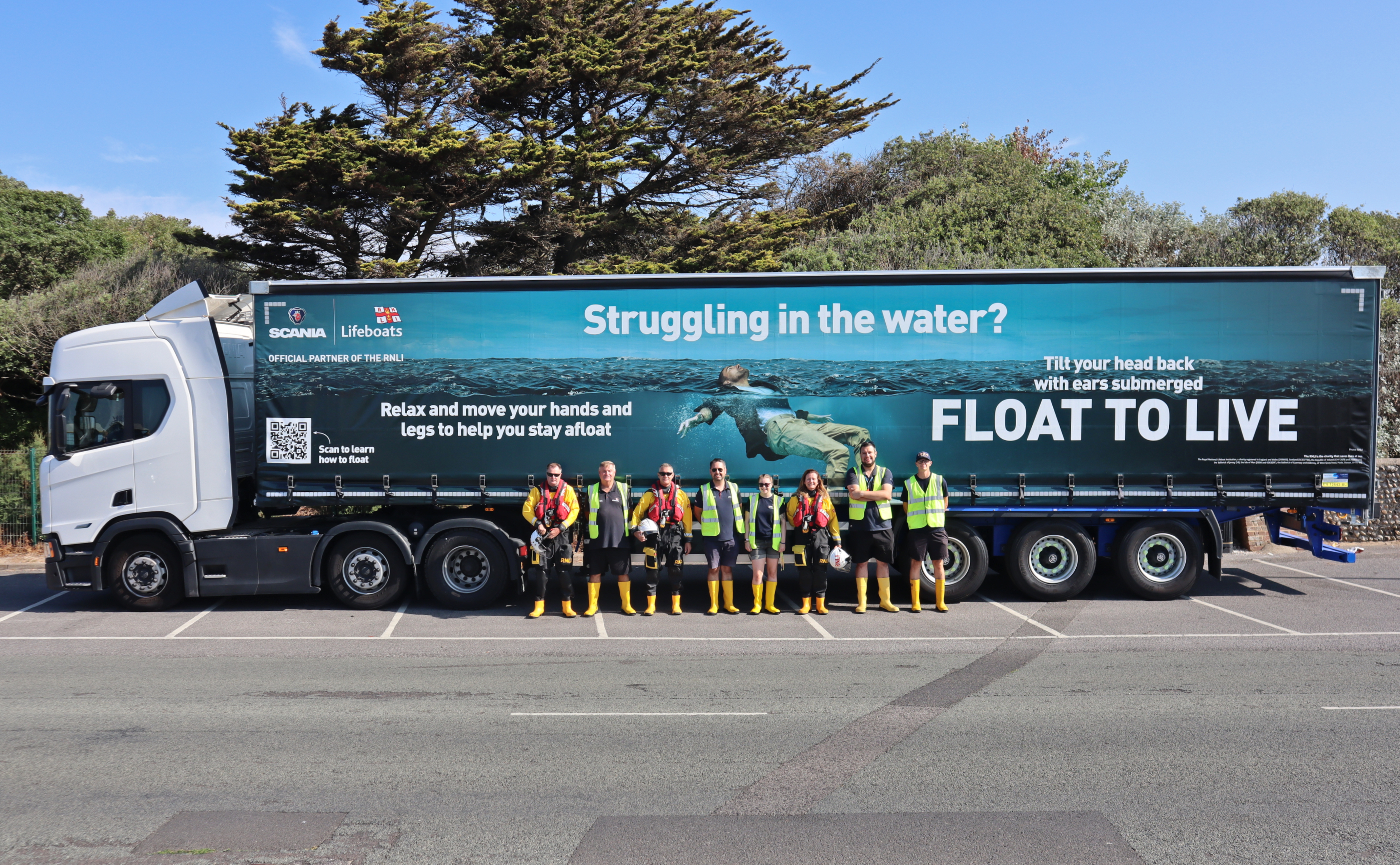 Eight volunteers from Littlehampton RNLI in full kit line up alongside the Scania/RNLI truck