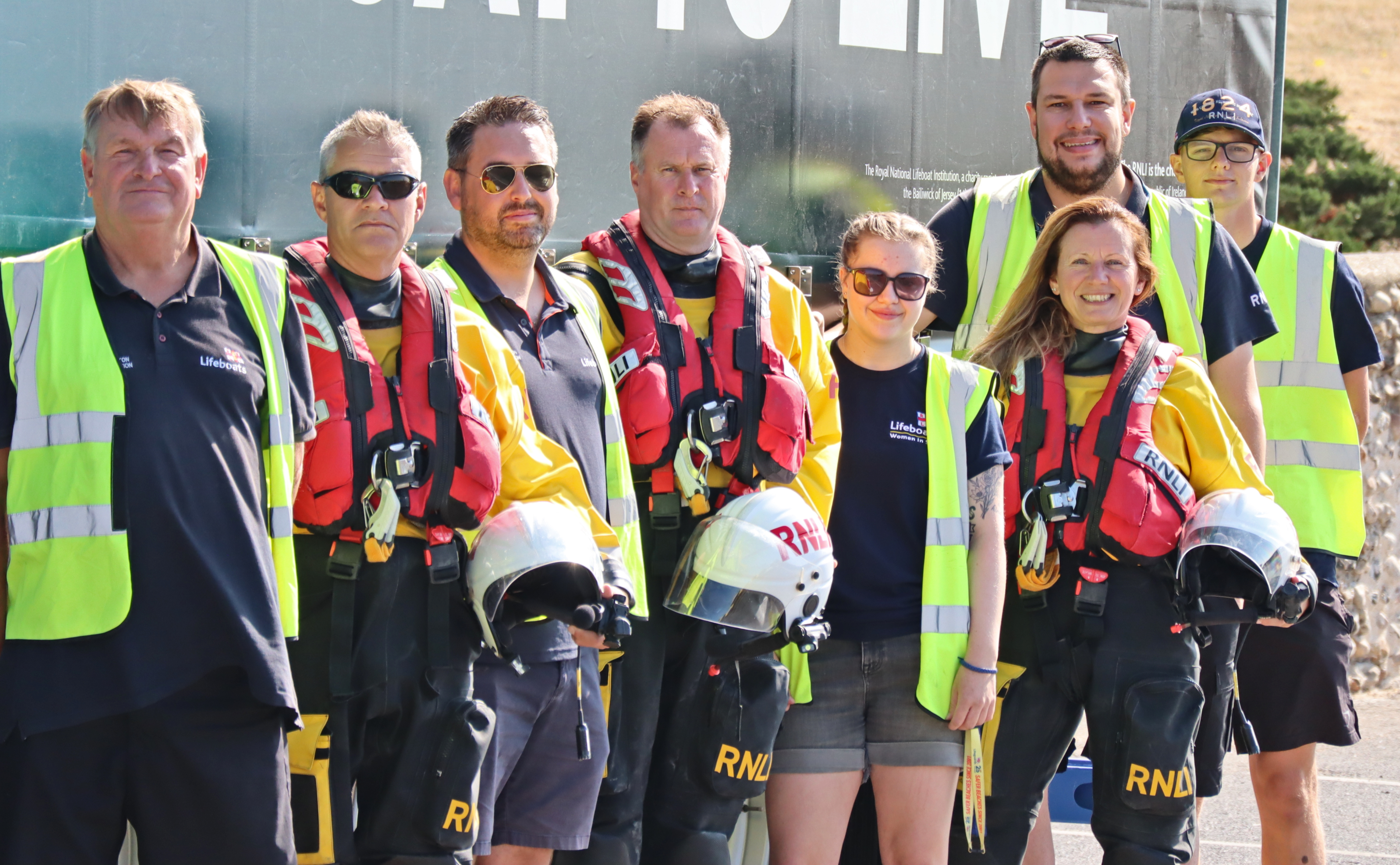Eight volunteers from Littlehampton RNLI in full kit line up alongside the Scania/RNLI truck